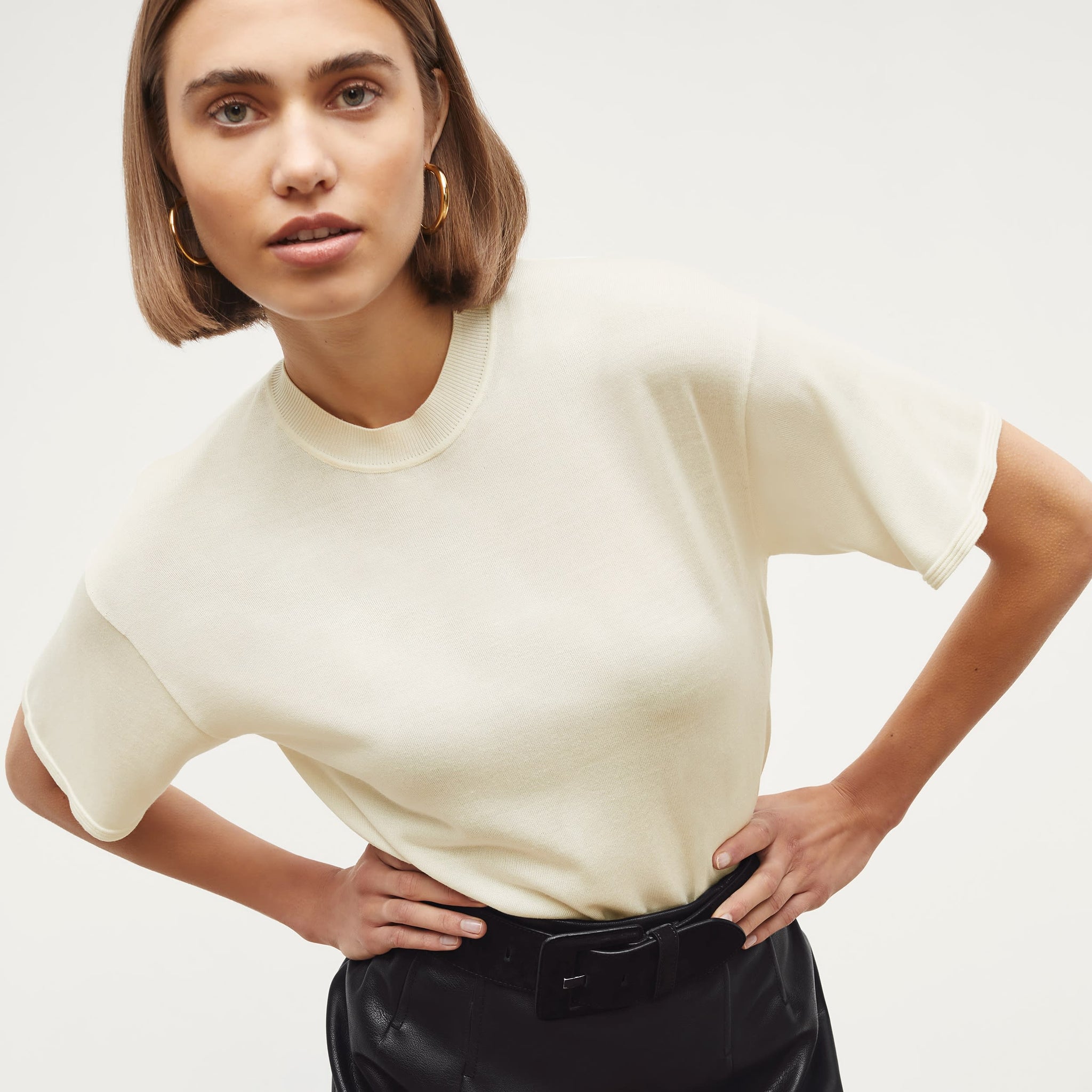 Front image of a woman standing wearing the mia top in silk jersey in cream