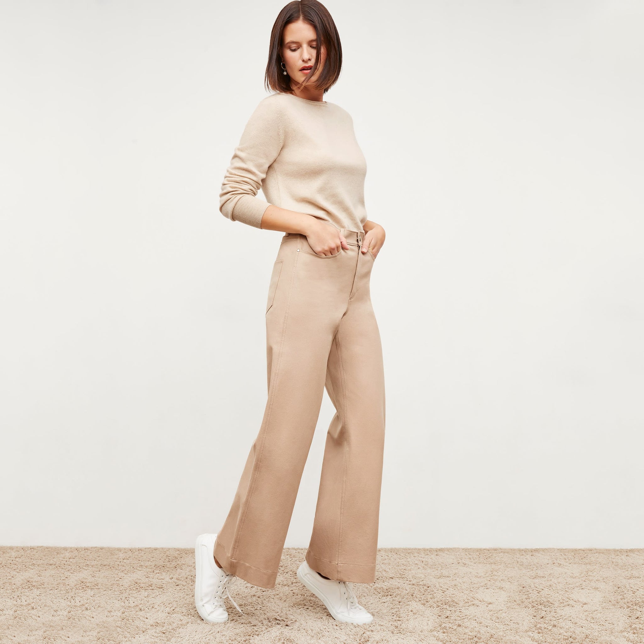 Front image of a woman standing wearing the Milo jean in Beige