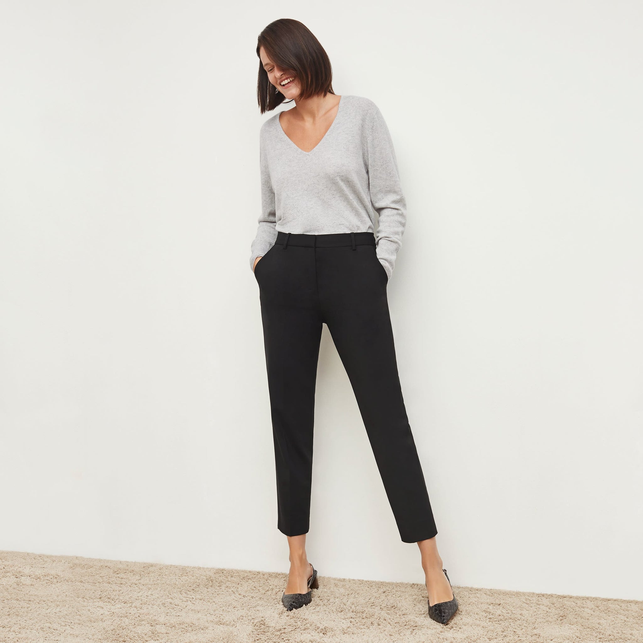 Front image of a woman standing wearing the Mejia pant in black 