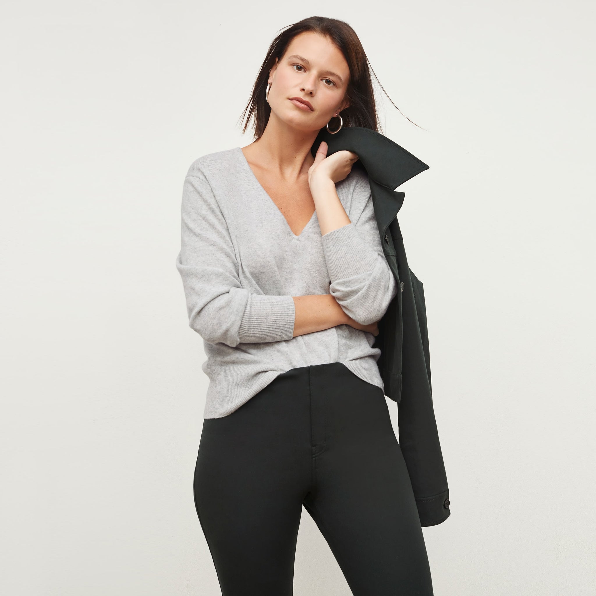 Front image of a woman standing wearing the martha sweater in light heather gray