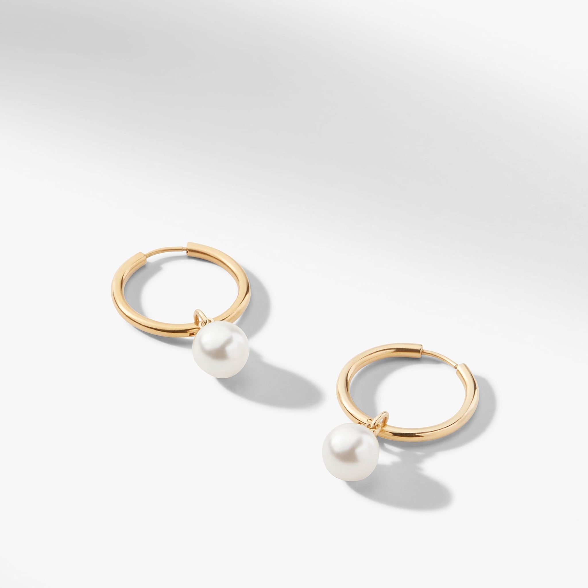still image of the Claude Charms in Gold on the claressa hoop small in gold 