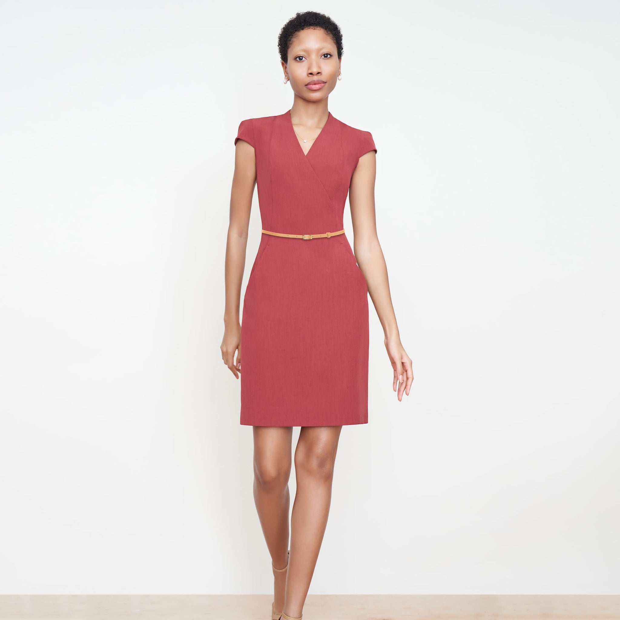 Front image of a woman standing wearing the Felisa dress in Brick Red 