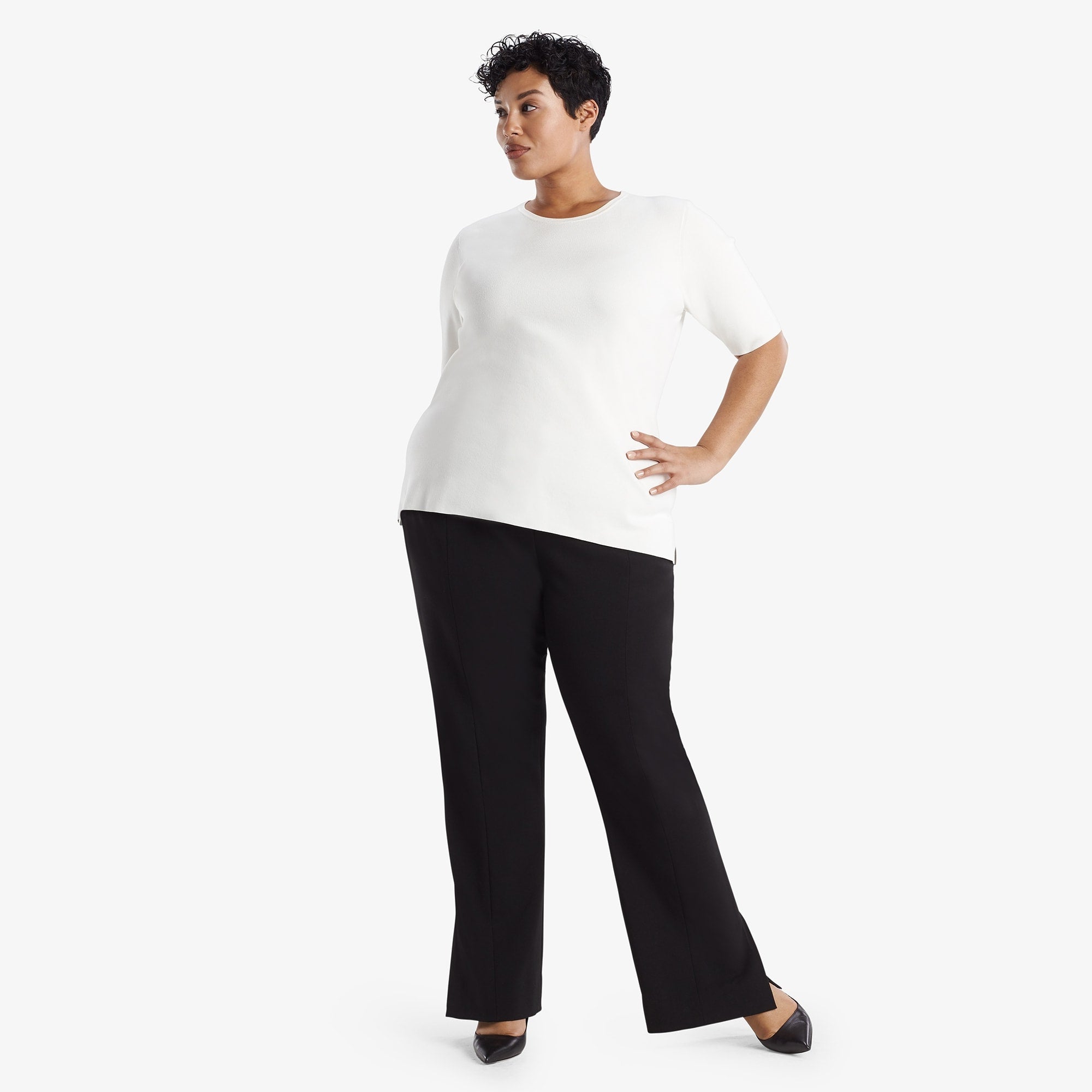 Hero image of a woman standing wearing the Mercado Pant in black 