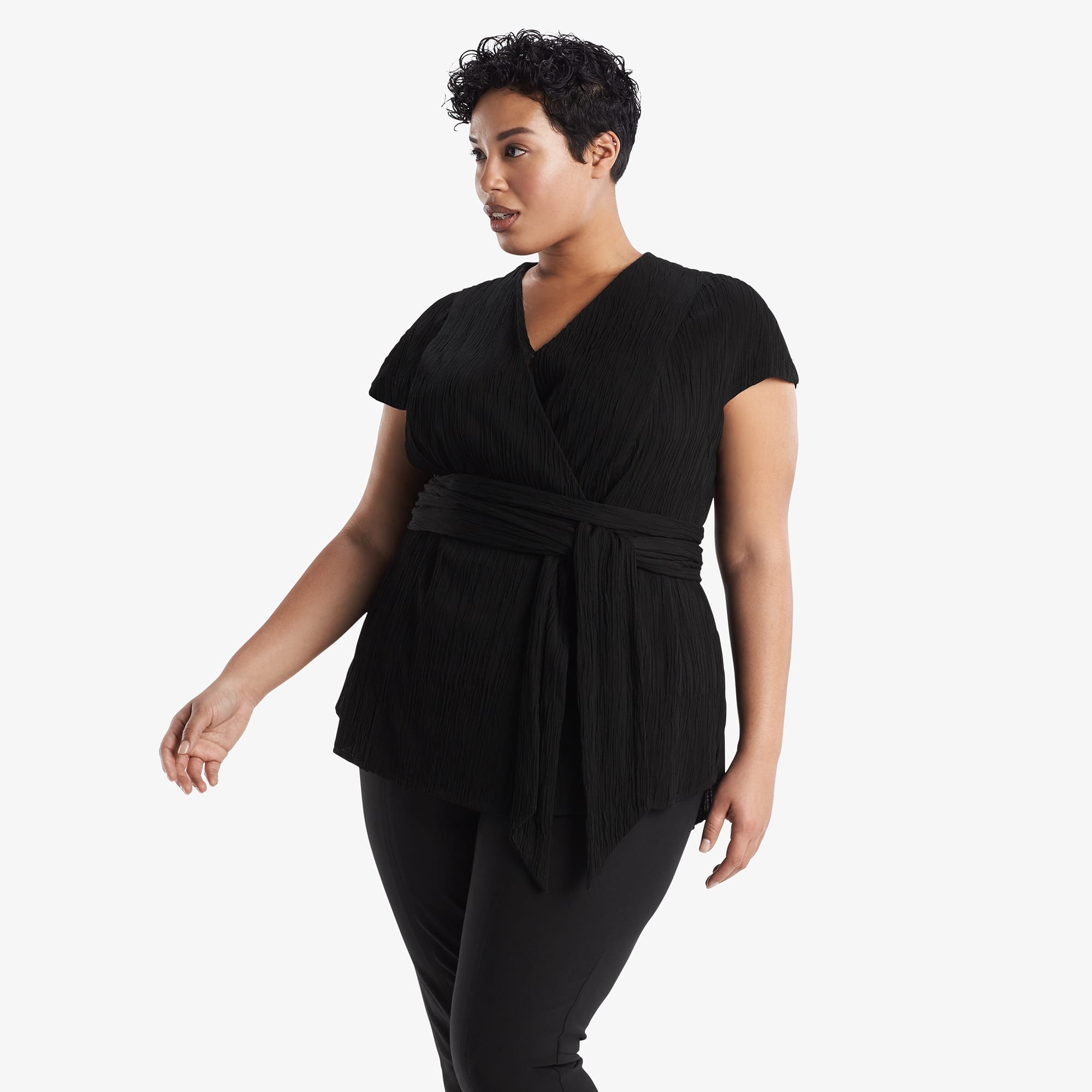 Side image of a woman standing wearing the Valerie Top in black