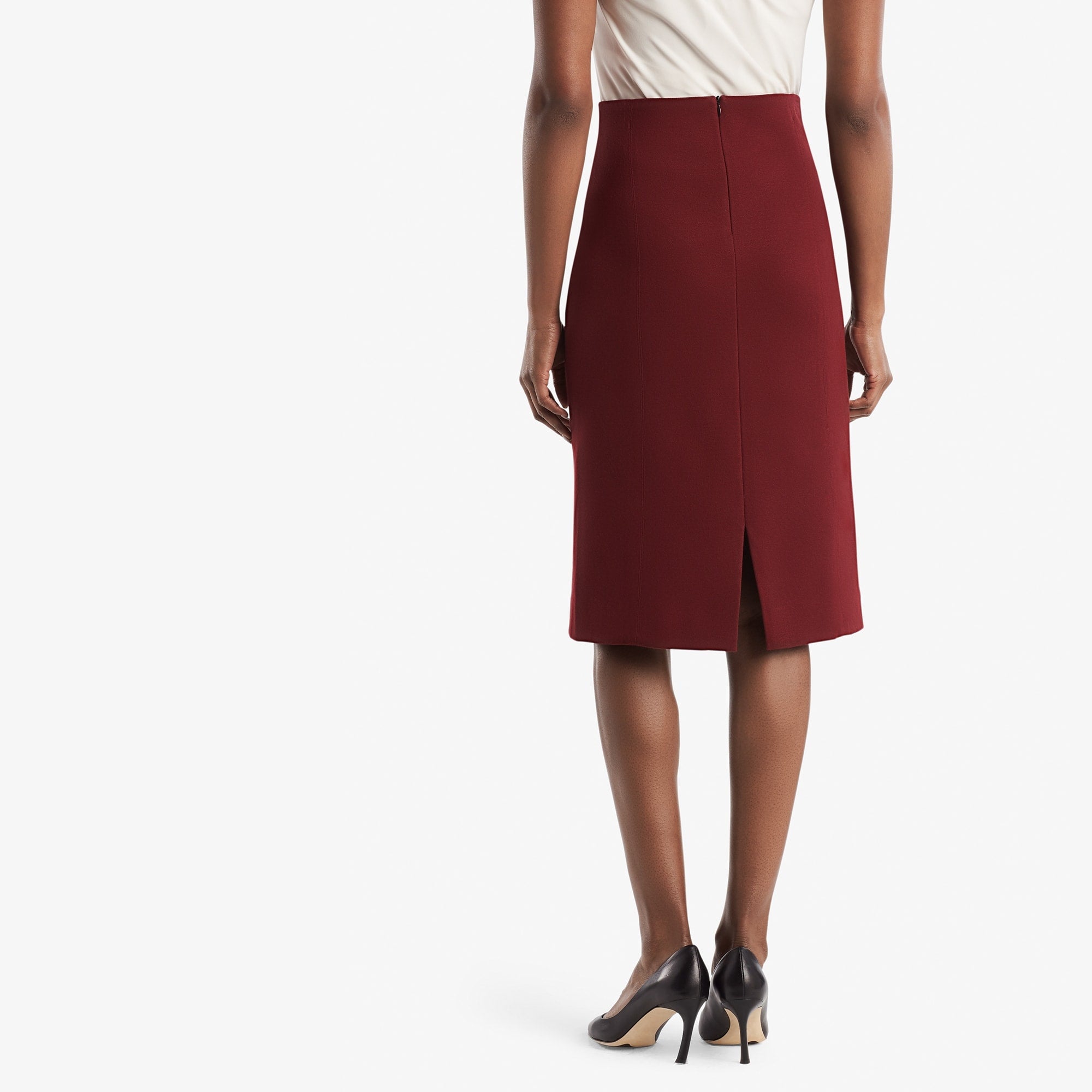 Back image of a woman standing wearing the Dorchester skirt in pinot