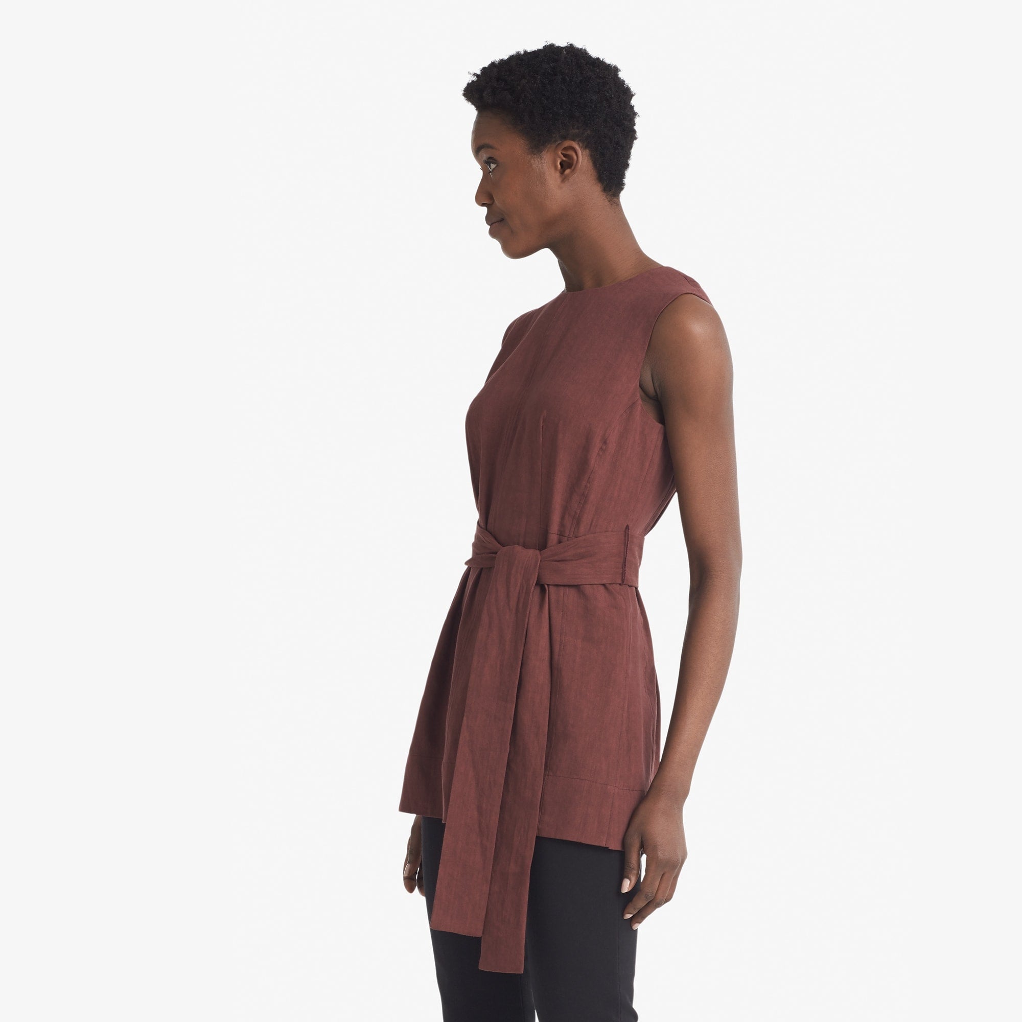 Side image of a woman standing wearing the Angelina top stretch linen in sumac
