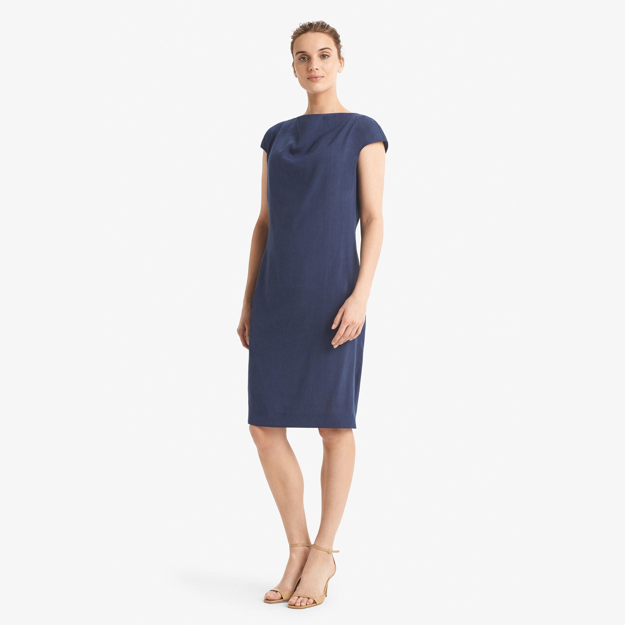 Side image of a woman standing wearing the Marilyn dress stretch linen in blueberry