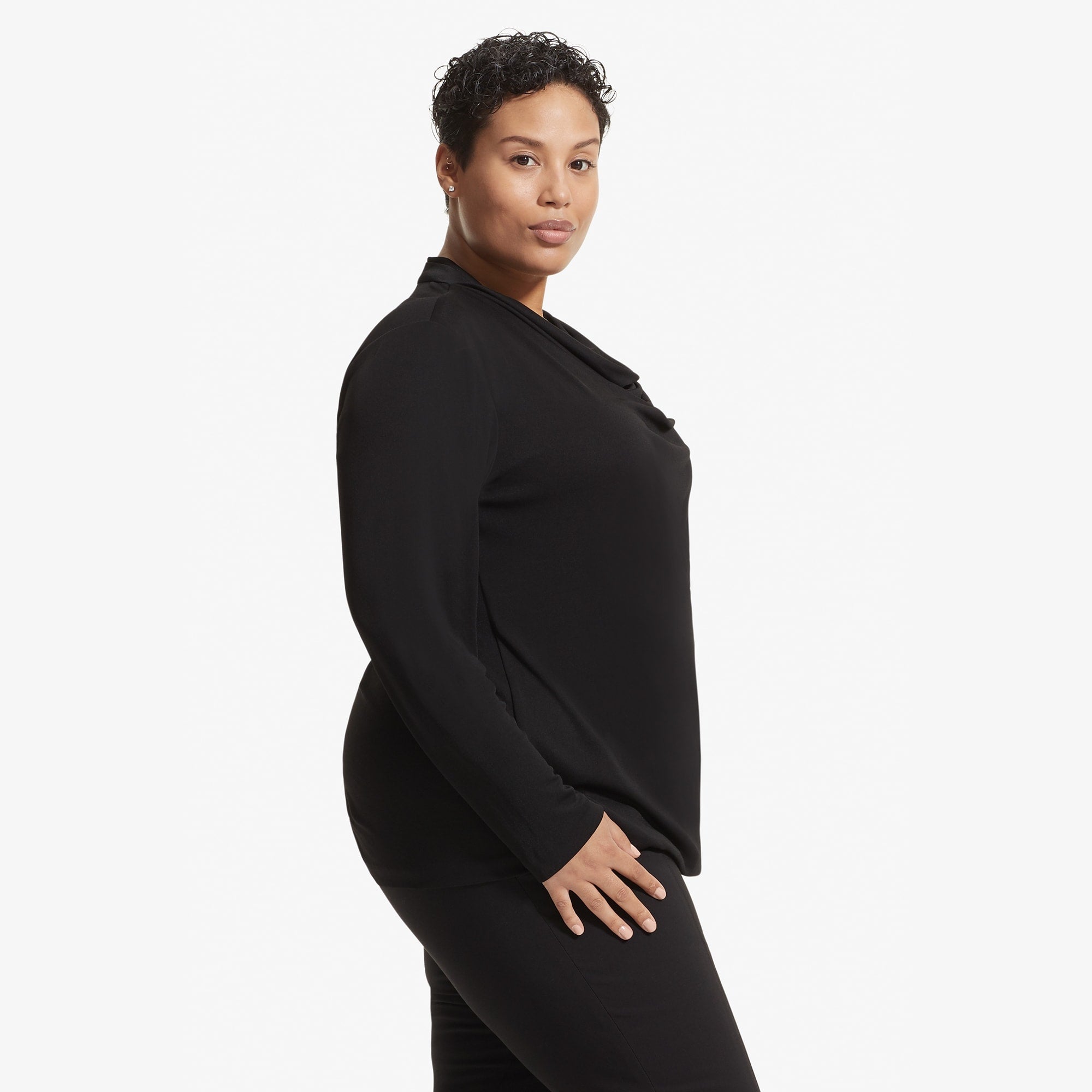 Side image of a woman standing wearing the Alma top in Black