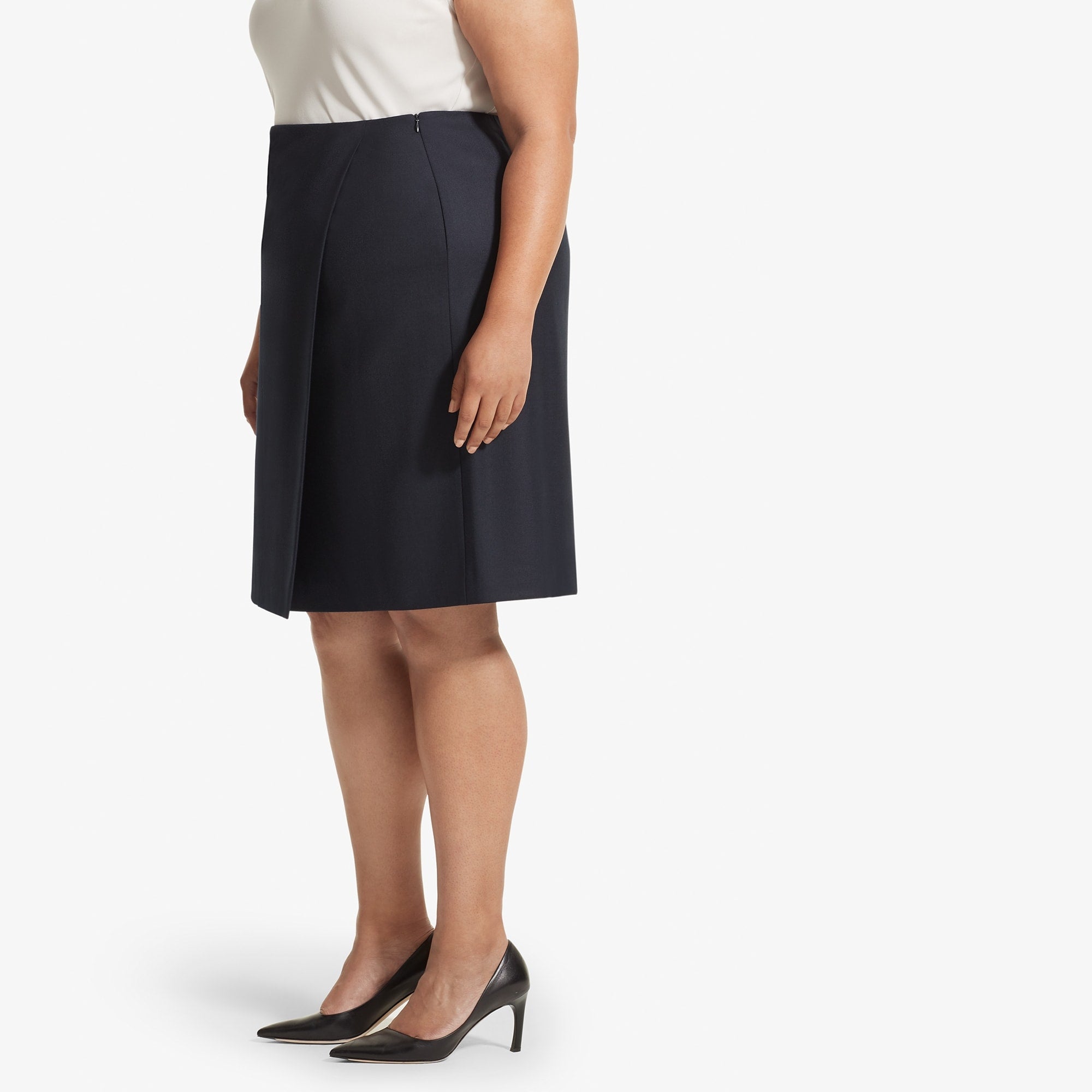 Side image of a woman standing wearing the Logan skirt sharkskin in Ink