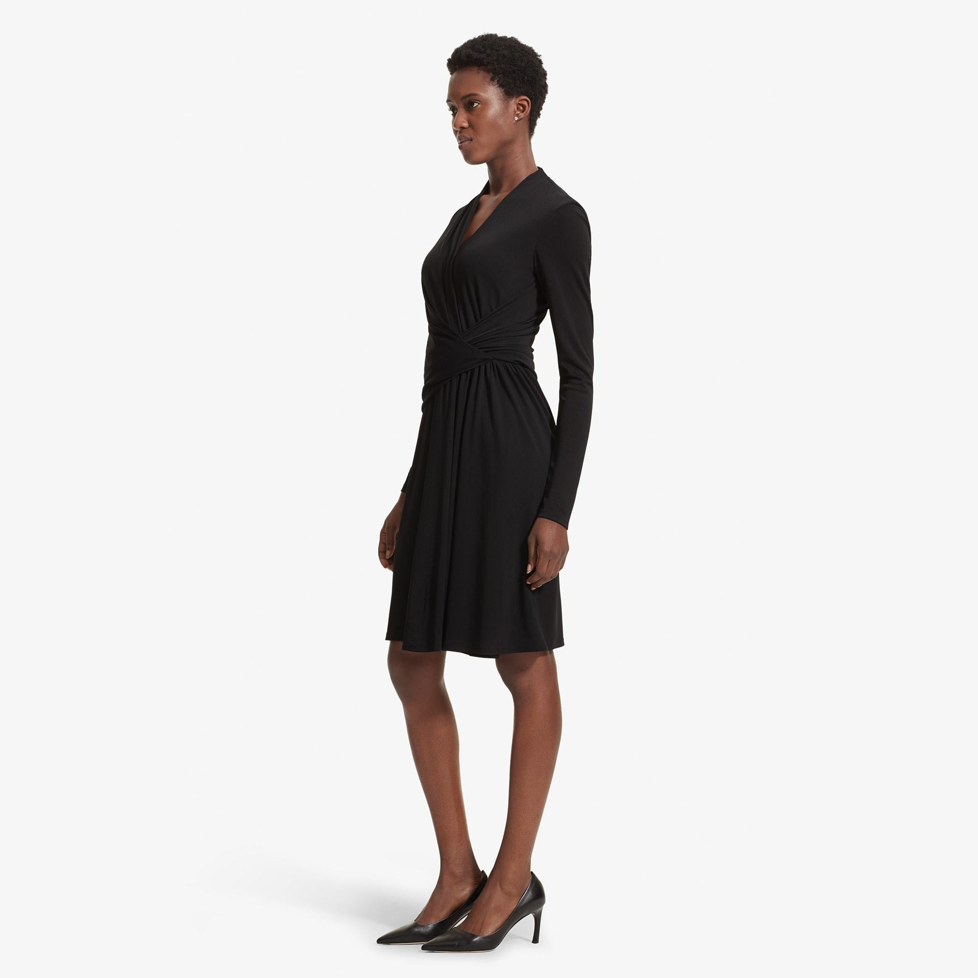Side image of a woman standing wearing the Morgan dress in Black