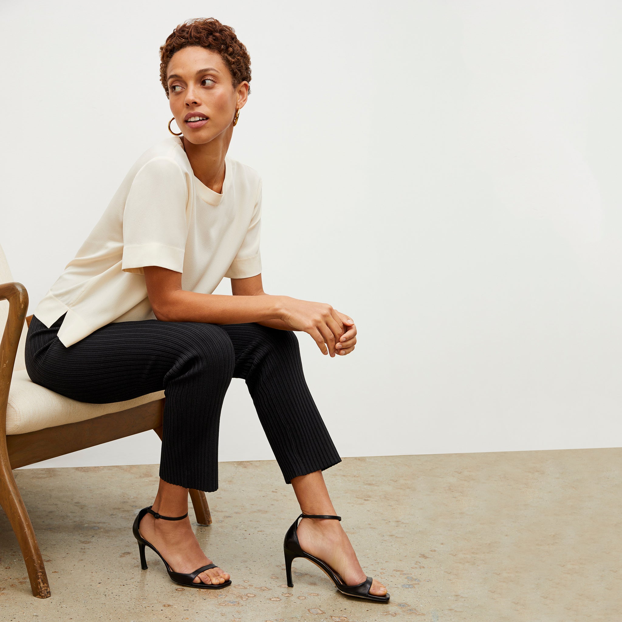Side image of a woman sitting wearing the Finley Legging—Ribbed Jardigan Knit in Black