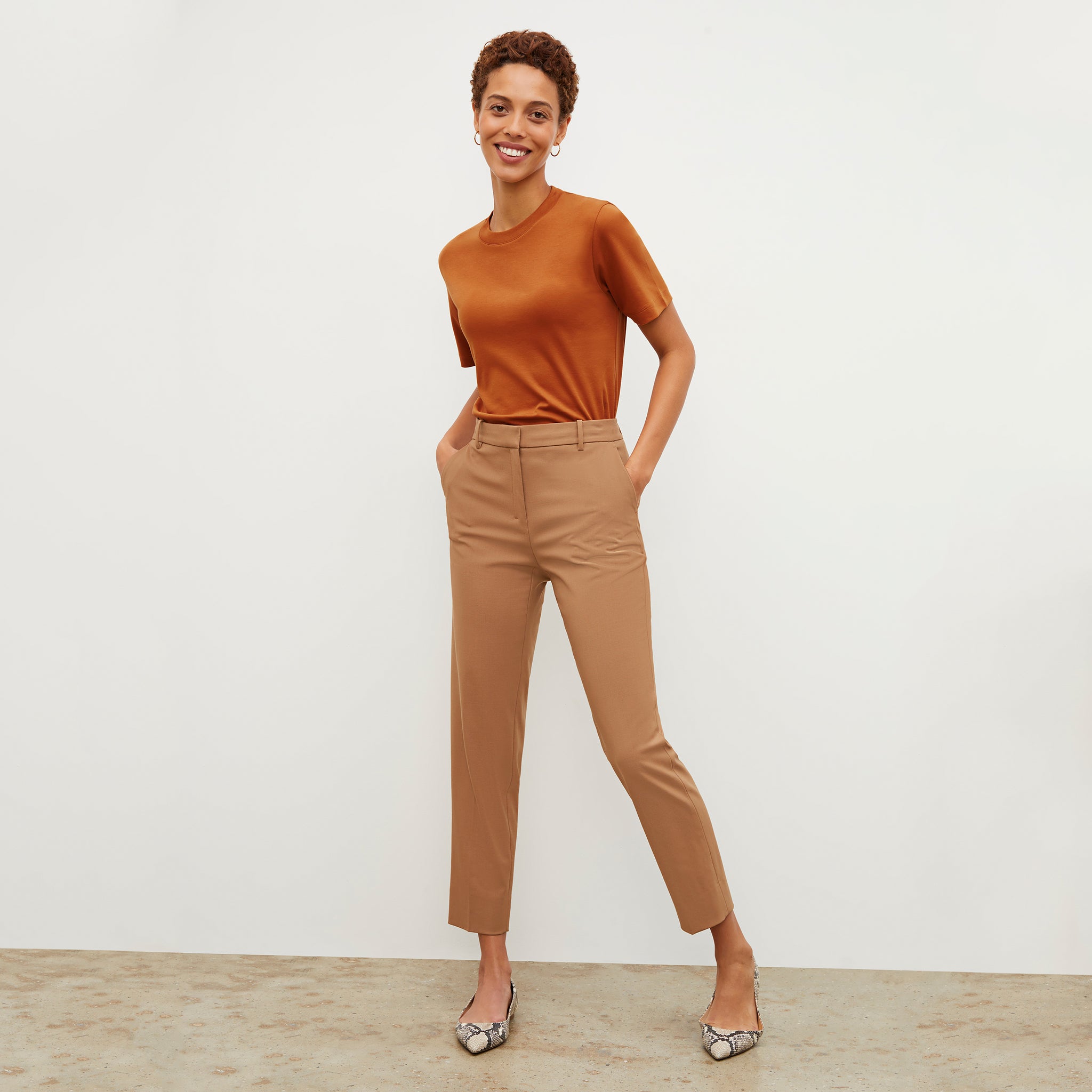 Front image of a woman standing wearing the Mejia pant in camel
