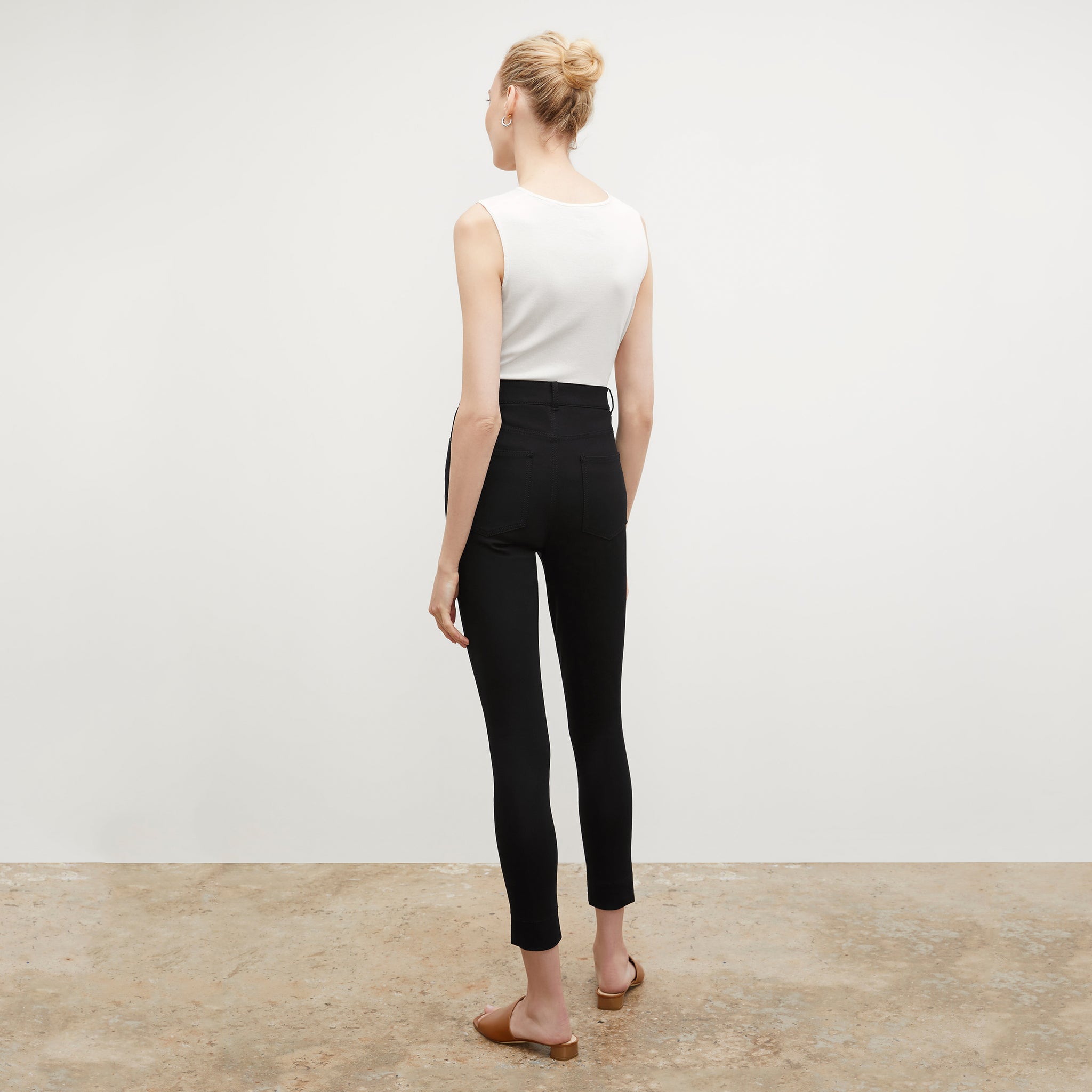 Front image of a woman standing wearing the paige top in fine ribbed cotton in ivory