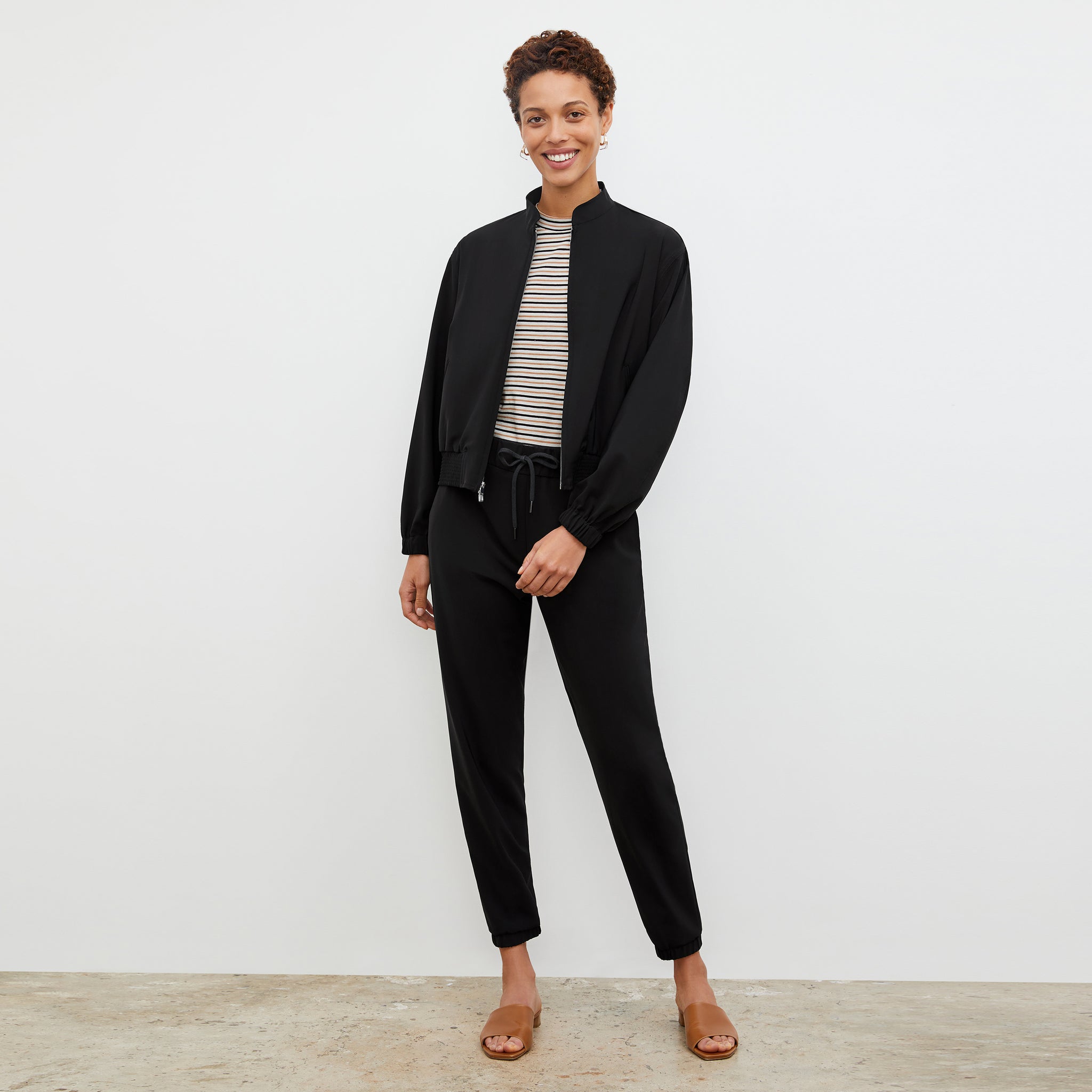 Front image of a woman standing wearing the Delaney Jogger—OrigamiTech in Black 