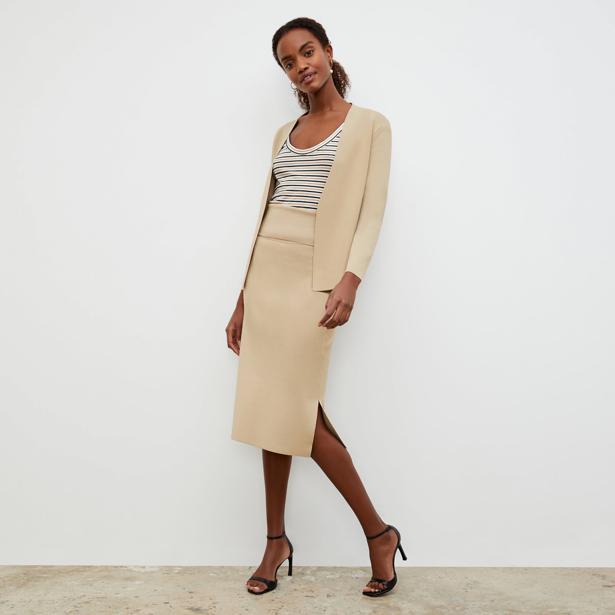 Front image of a woman standing wearing the Harlem skirt in latte