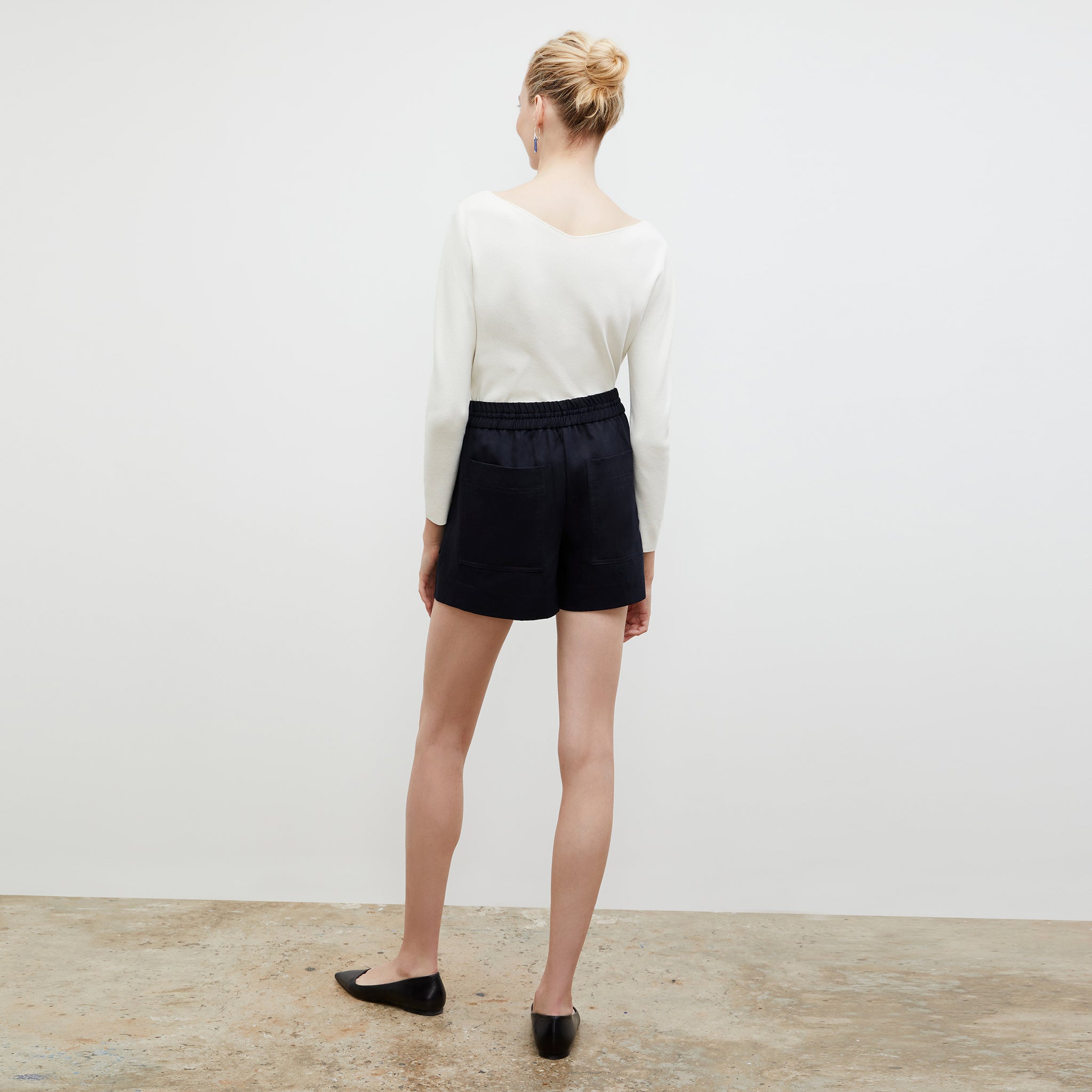 Back image of a woman standing wearing the celeste top in ivory