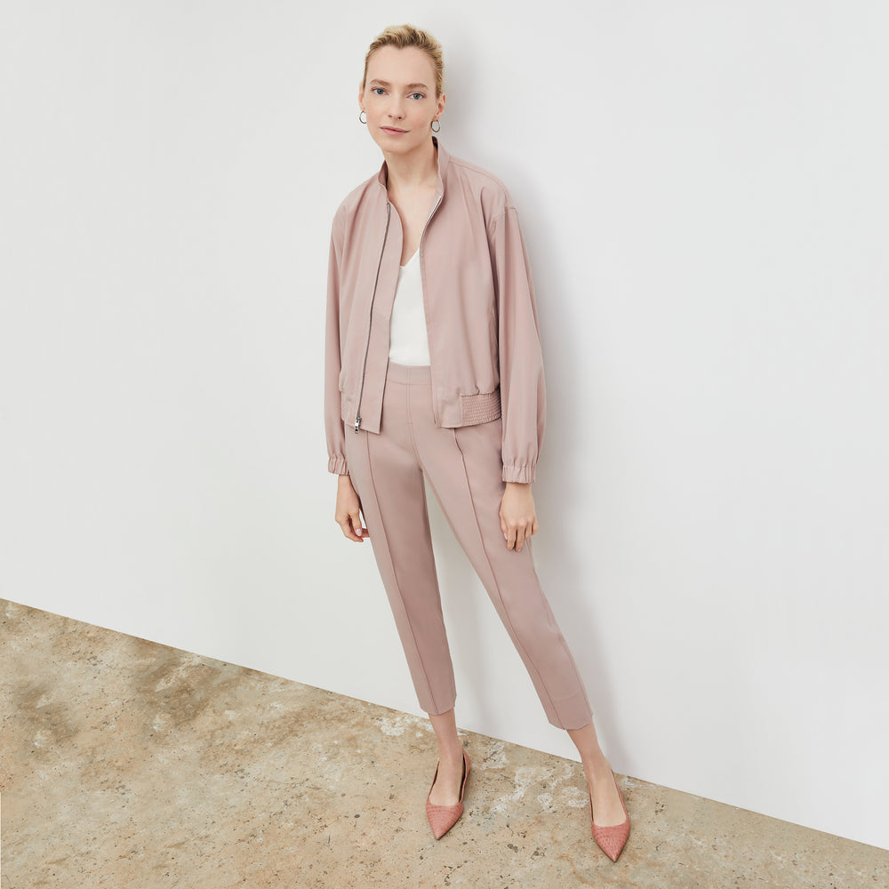 Front image of a woman wearing the Langely Bomber in Origamitech in Blush