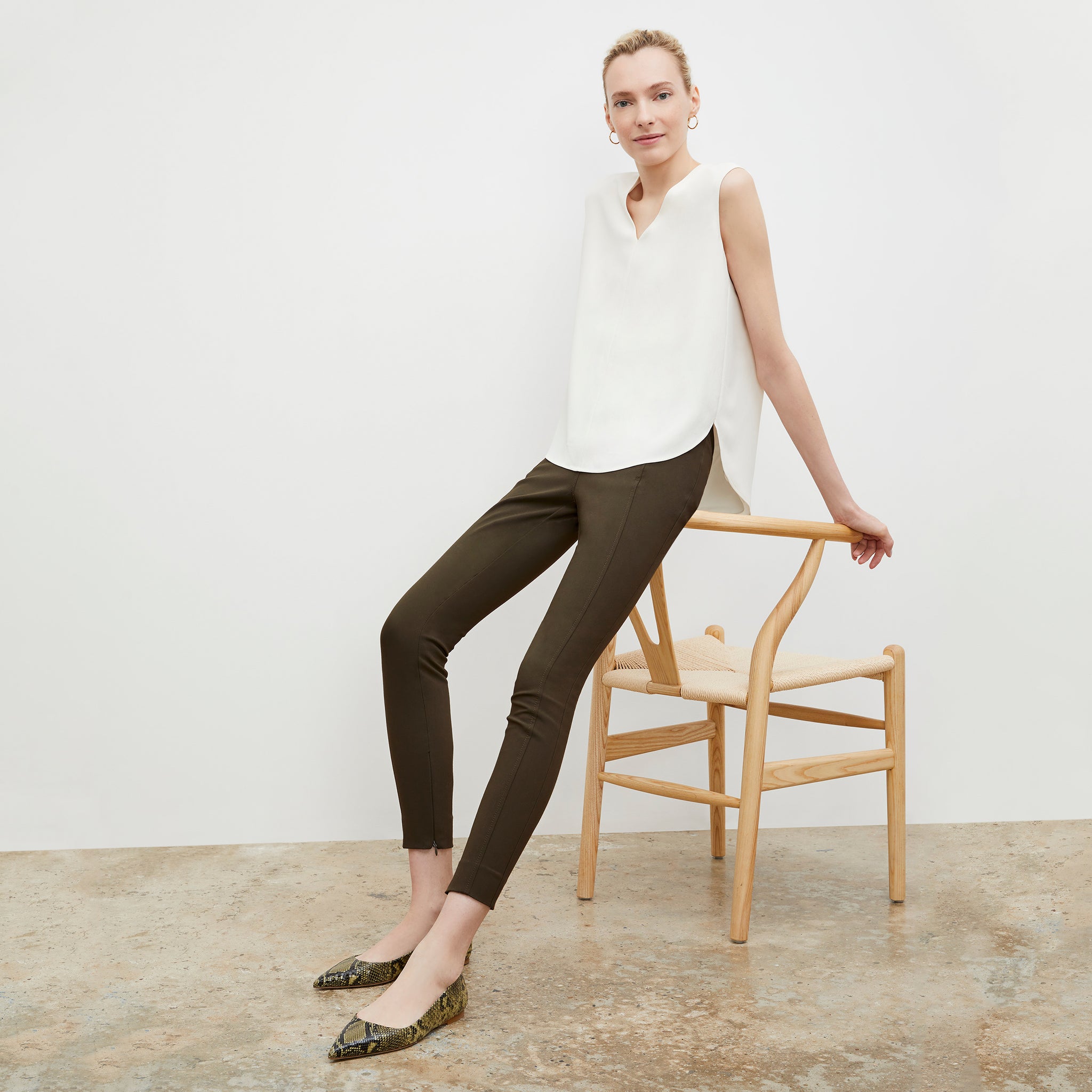 Front image of a woman wearing the Rowan flats in Black/Olive Snakeskin 