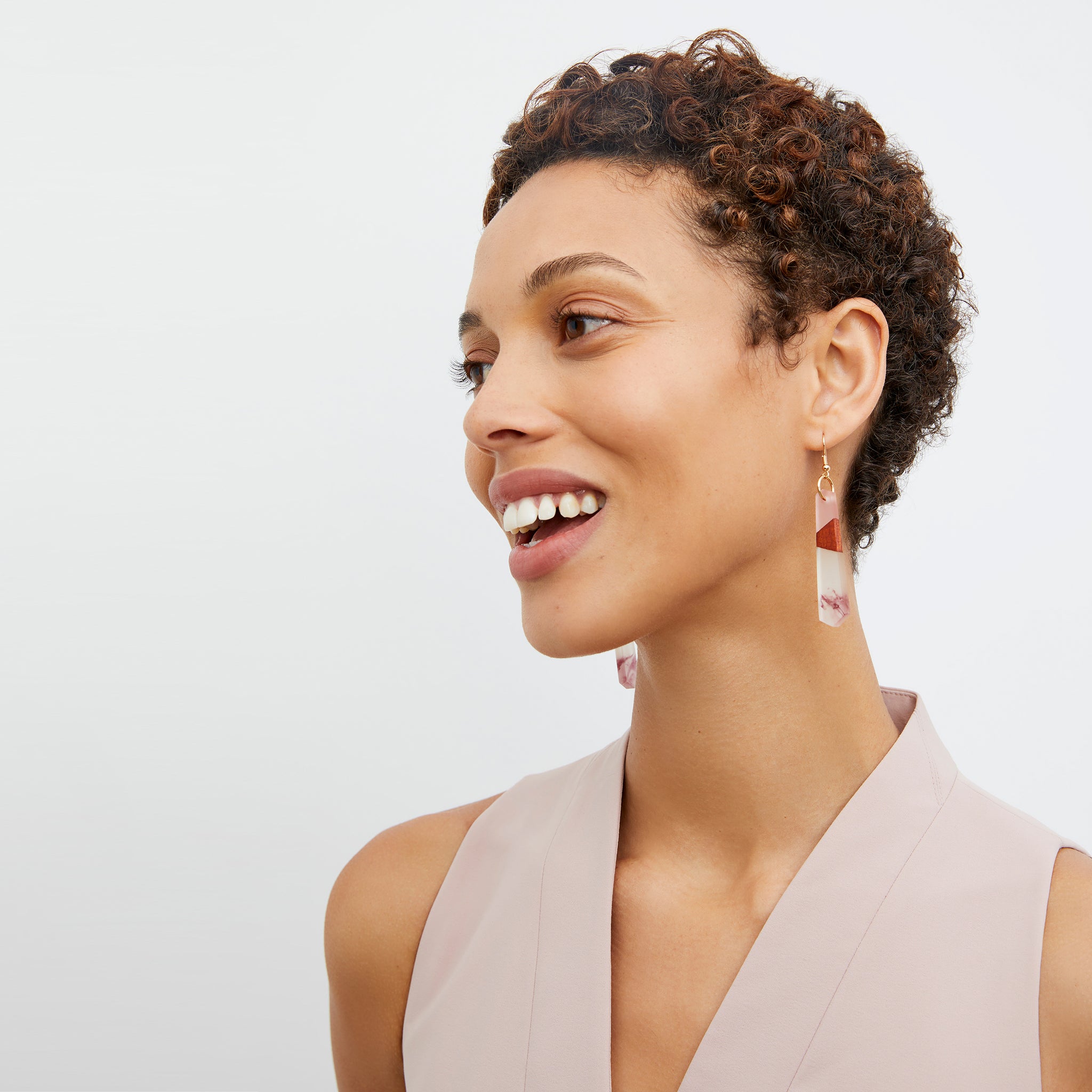 image of a woman wearing the noemi earrings in rose / mahogany