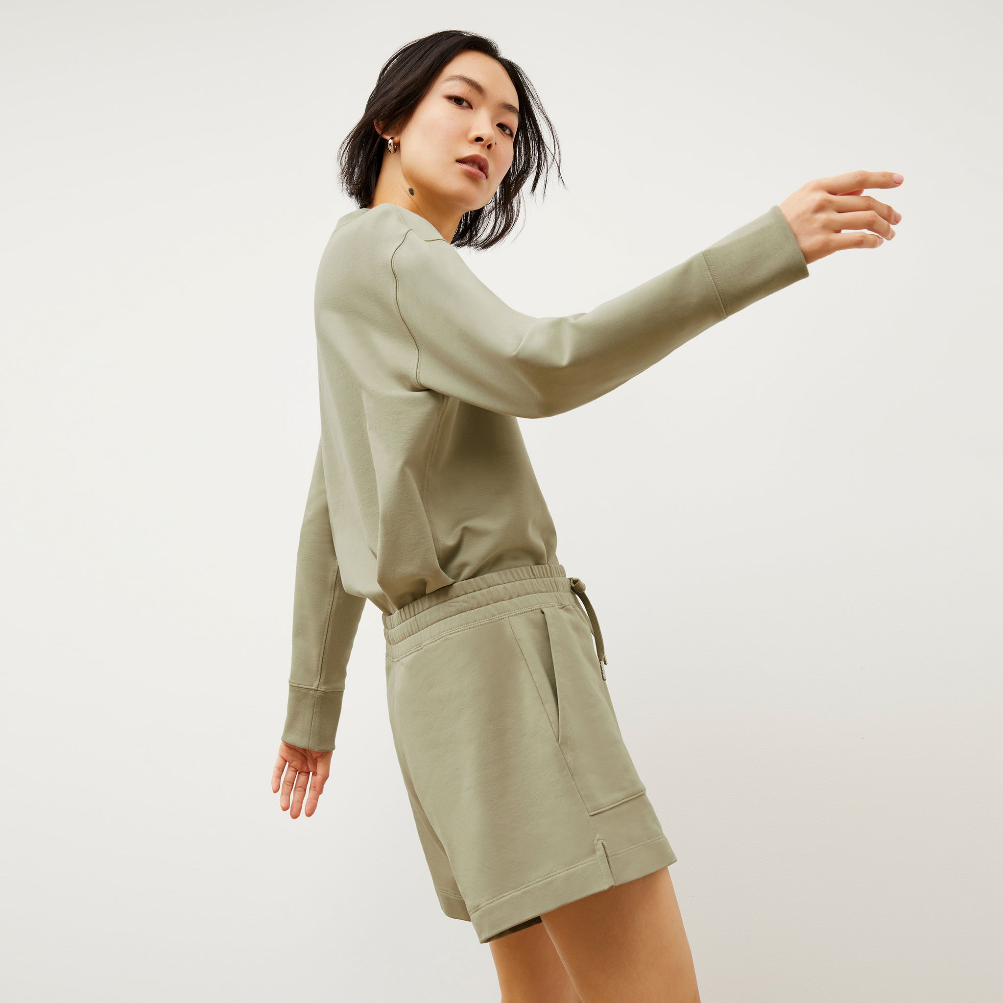 Side image of a woman wearing the Ellie Pullover - Light French Terry in Laurel Green