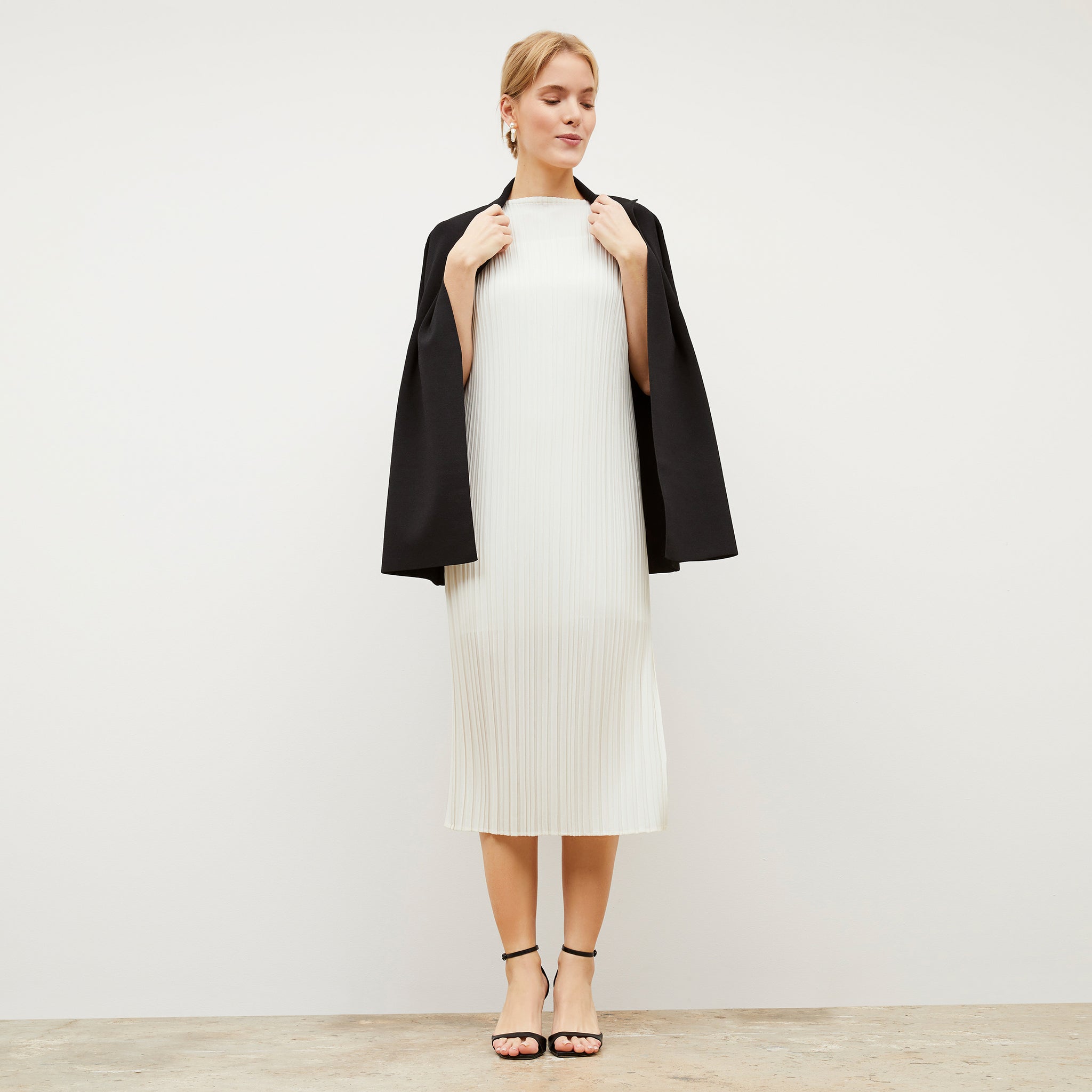Front image of a woman wearing the Edith Dress - Micro Pleat in Ivory