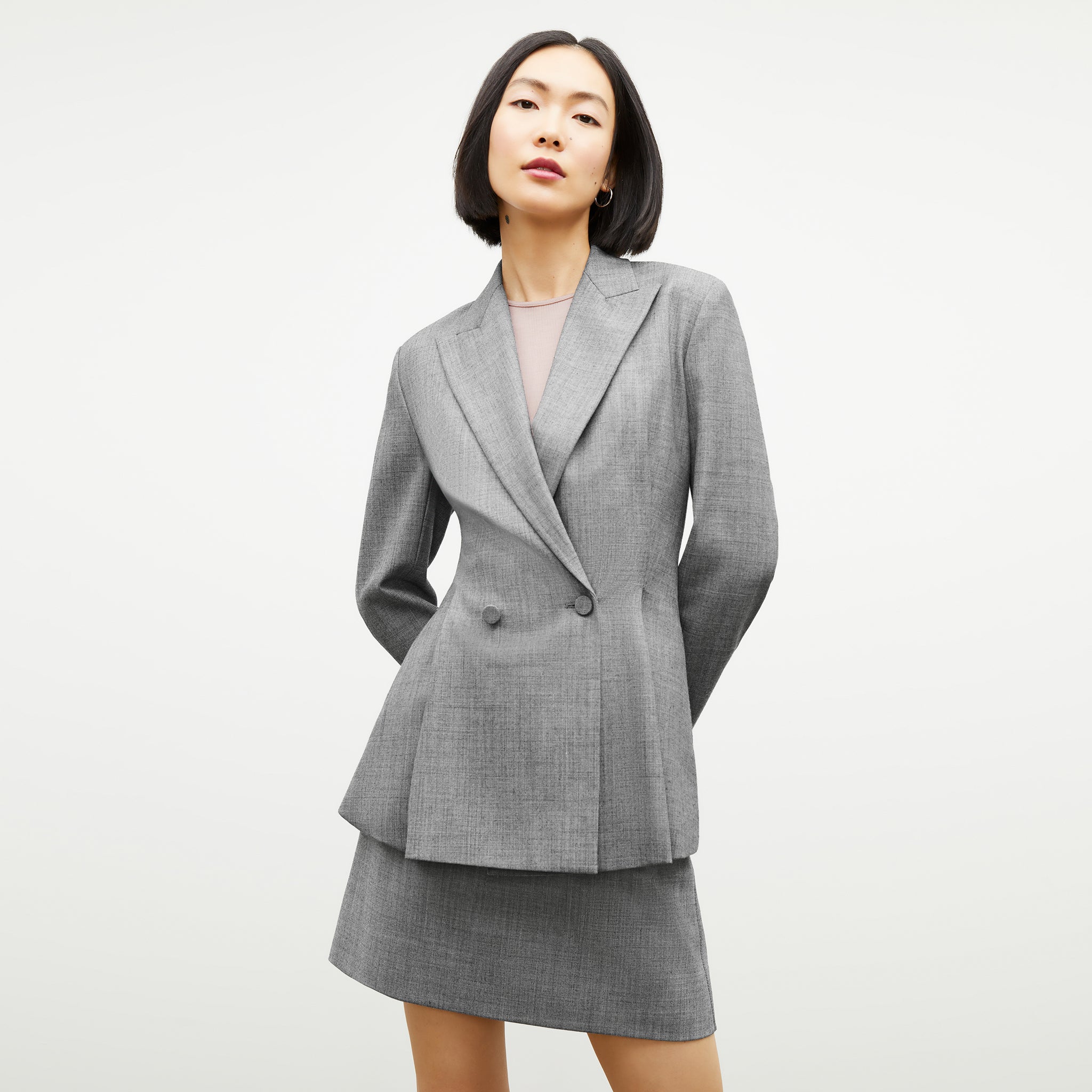 Front image of a woman standing wearing the gaia jacket in sharkskin in black and white