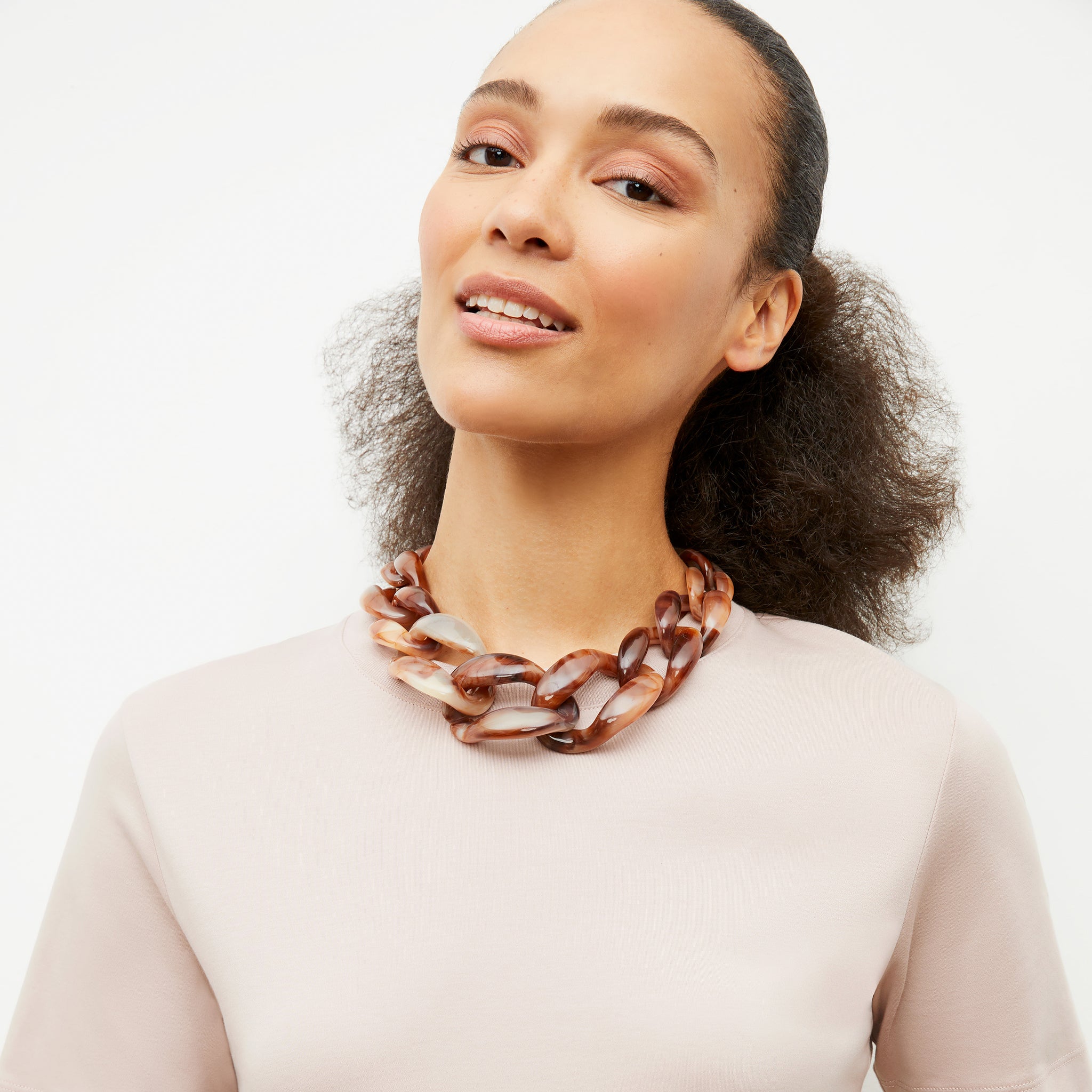 image of a woman wearing the lygia necklace in ivory / brown multi