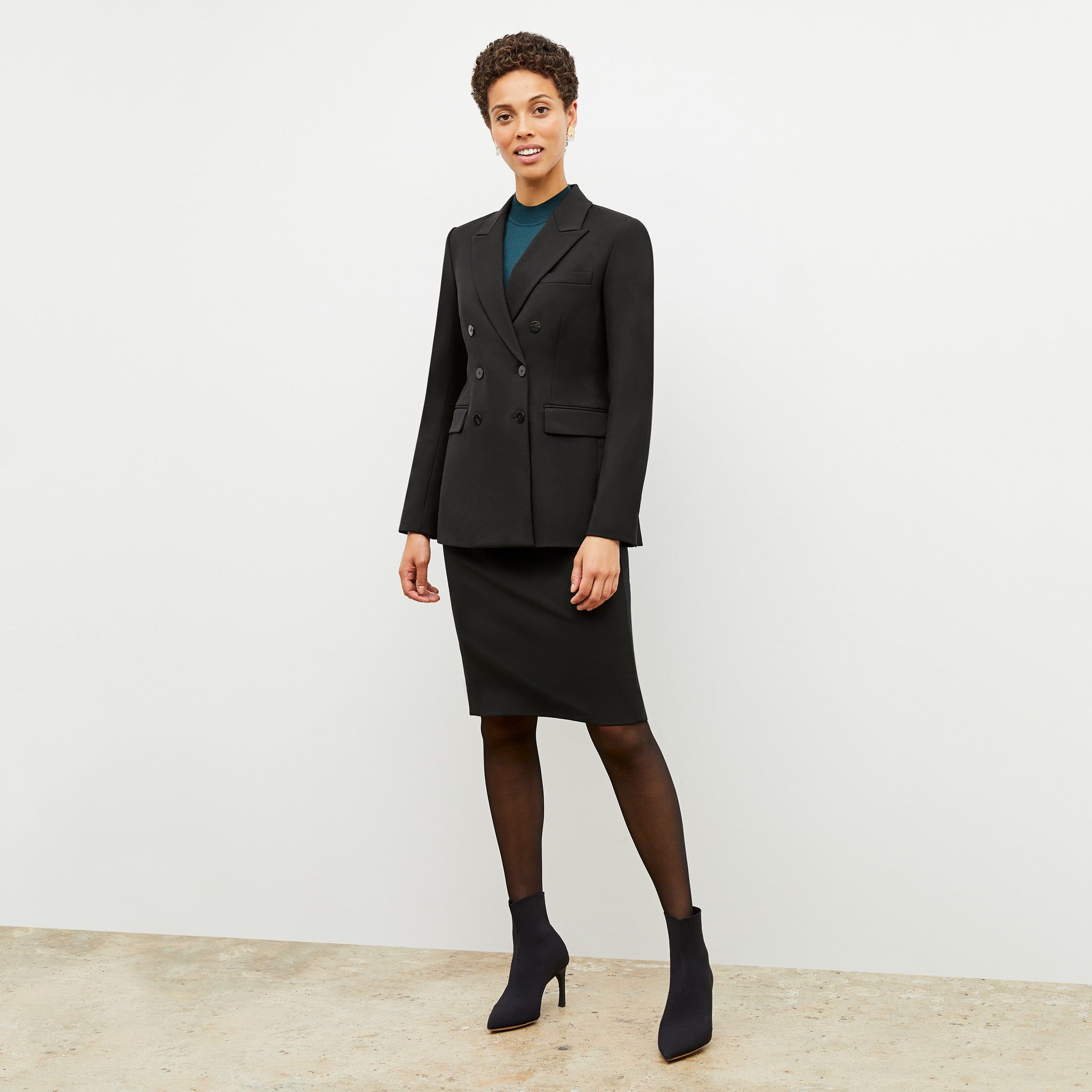 Front image of a woman standing wearing the Cobble Hill Skirt—Washable Wool Twill in Black