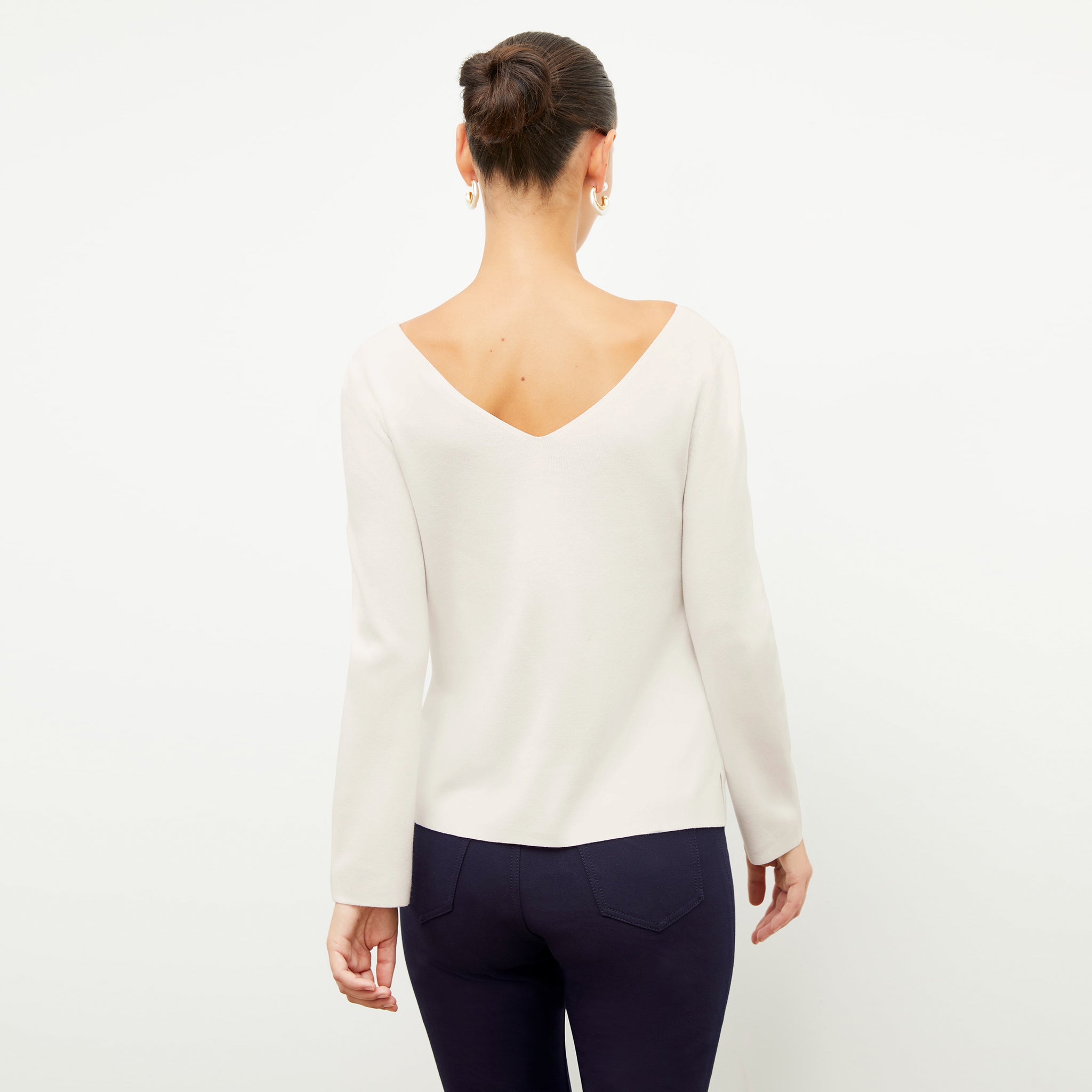 Back image of a woman wearing the kara top in ivory 