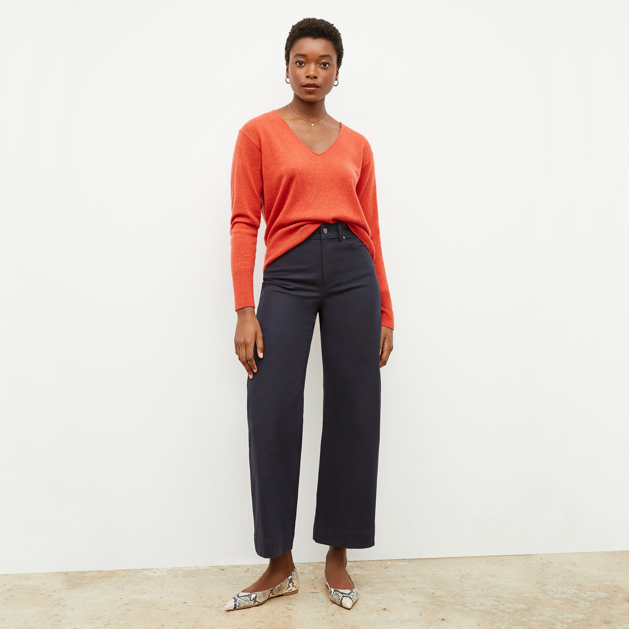 Front image of a woman wearing the martha sweater in papaya