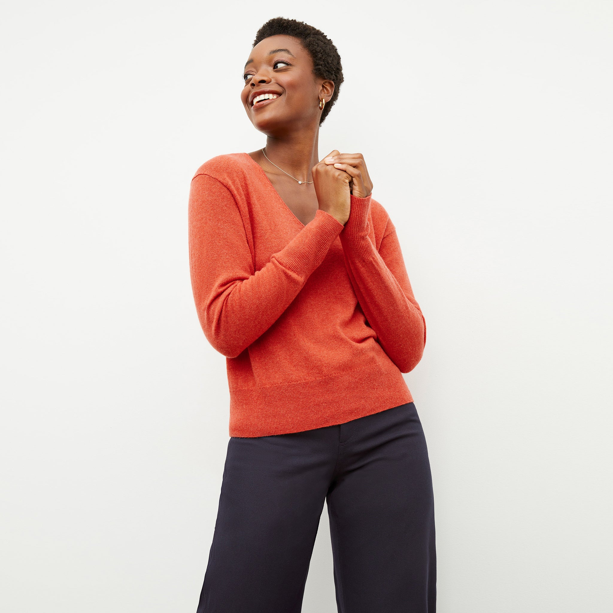 Front image of a woman wearing the martha sweater in papaya 