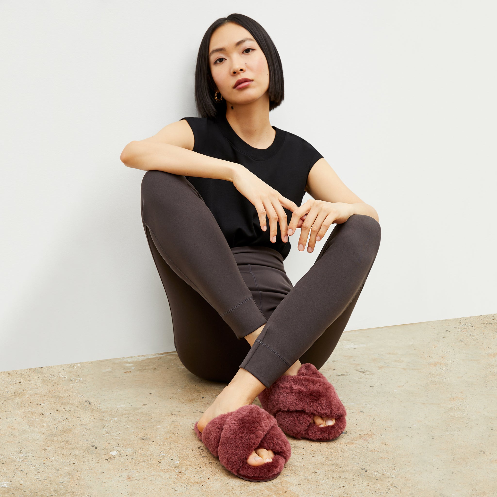 Front image of a woman wearing the emu slipper in merlot