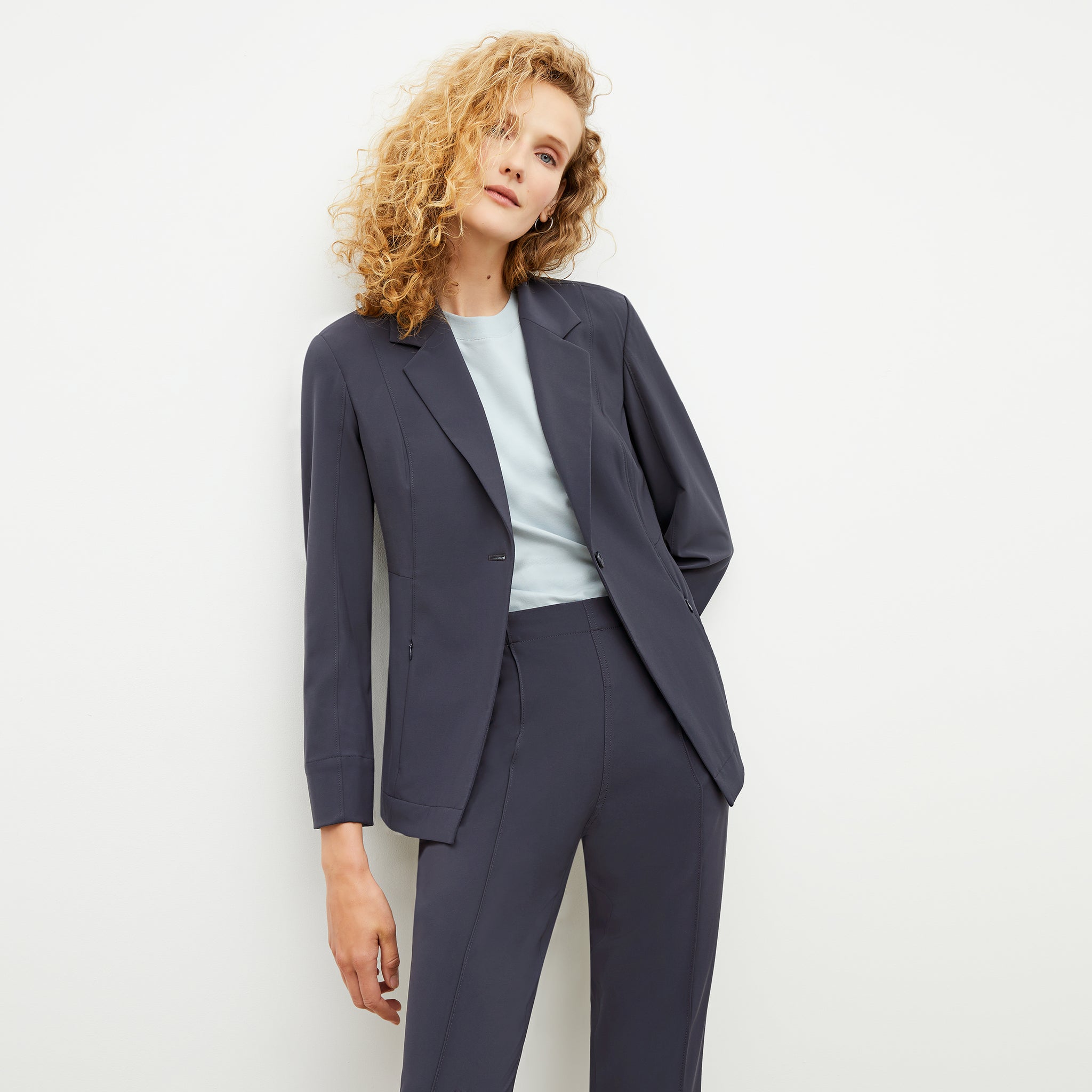 Front image of a woman sitting wearing the Moreland Jacket—Origami Suiting in Cool Charcoal 