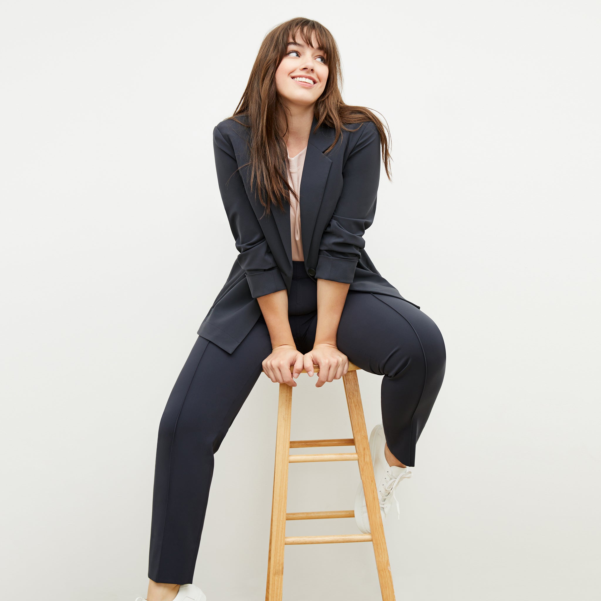 Front image of a woman sitting wearing the Moreland Jacket—Origami Suiting in Cool Charcoal 