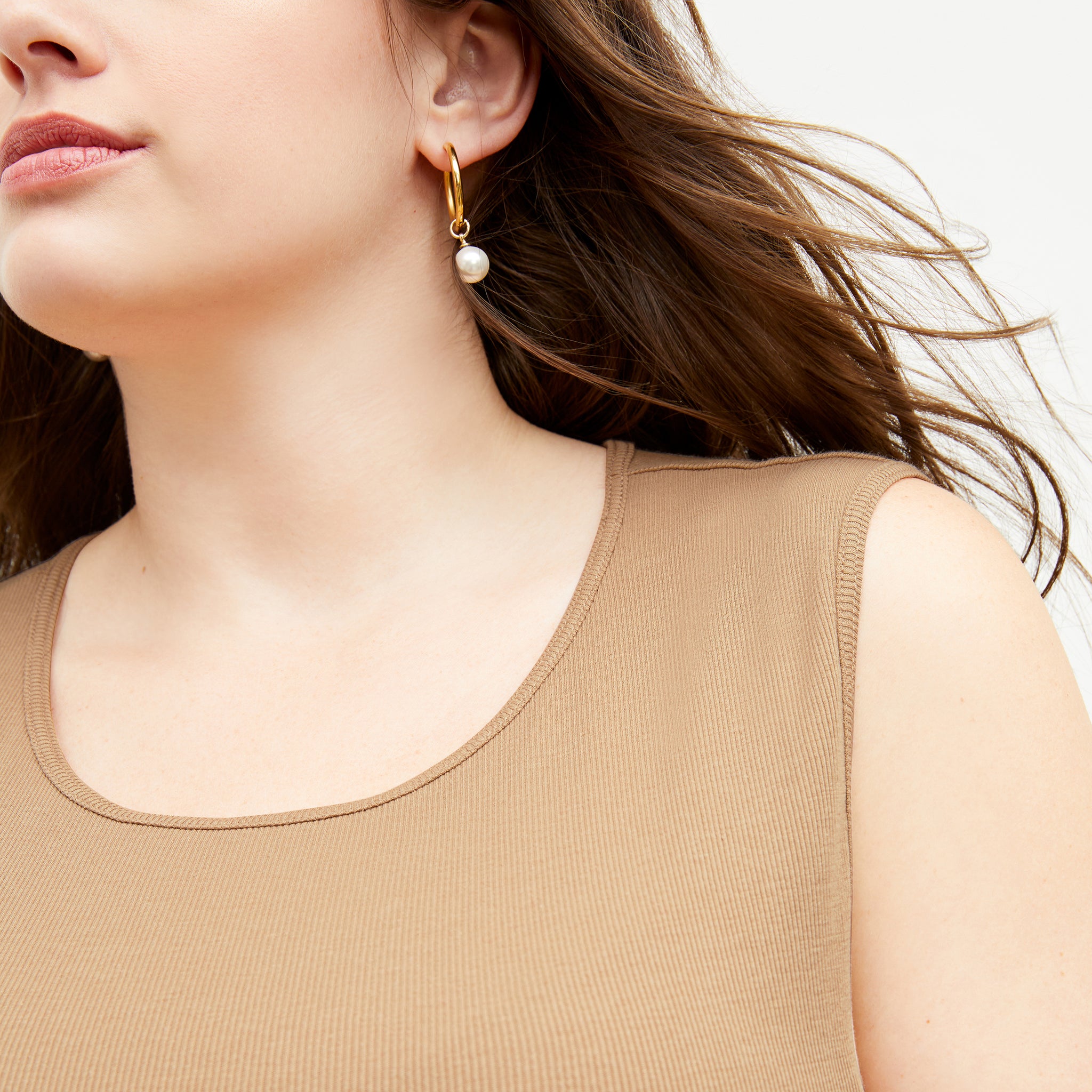 Front image of a woman standing wearing the Paige T-Shirt—Fine Ribbed Cotton in Camel