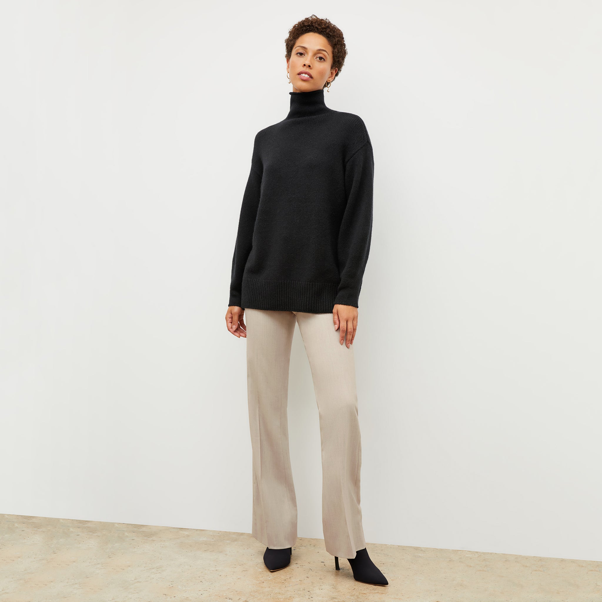 Front image of a woman wearing the lea sweater in black