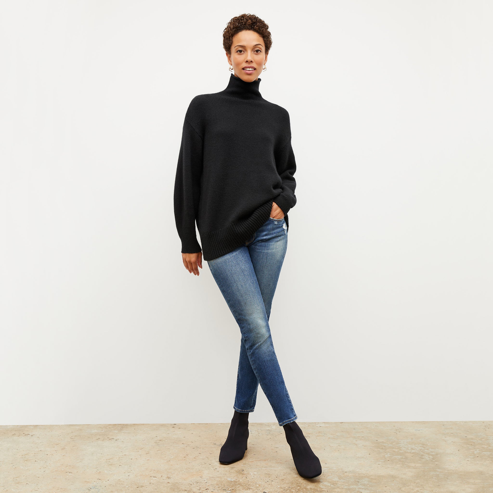 Front image of a woman wearing the lea sweater in black 