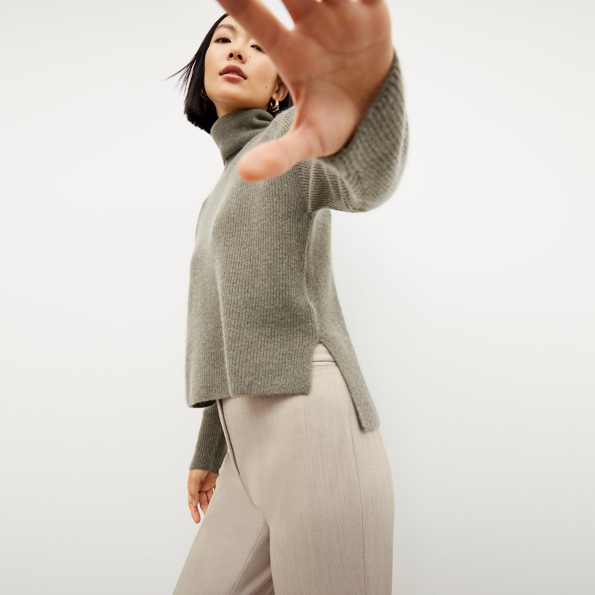 Front image of a woman wearing the arbus sweater in dark moss