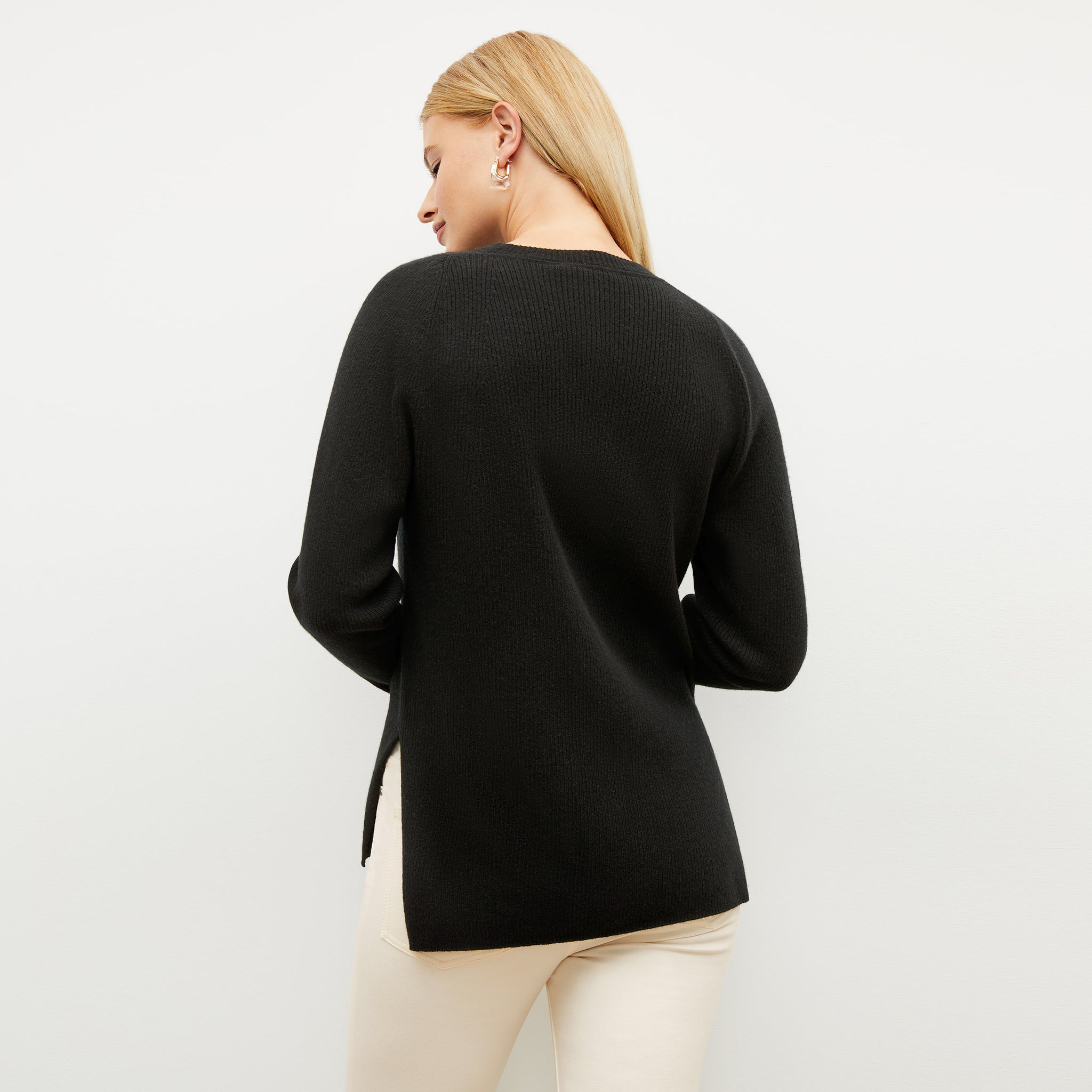 Black image of a woman wearing the ollie sweater in black