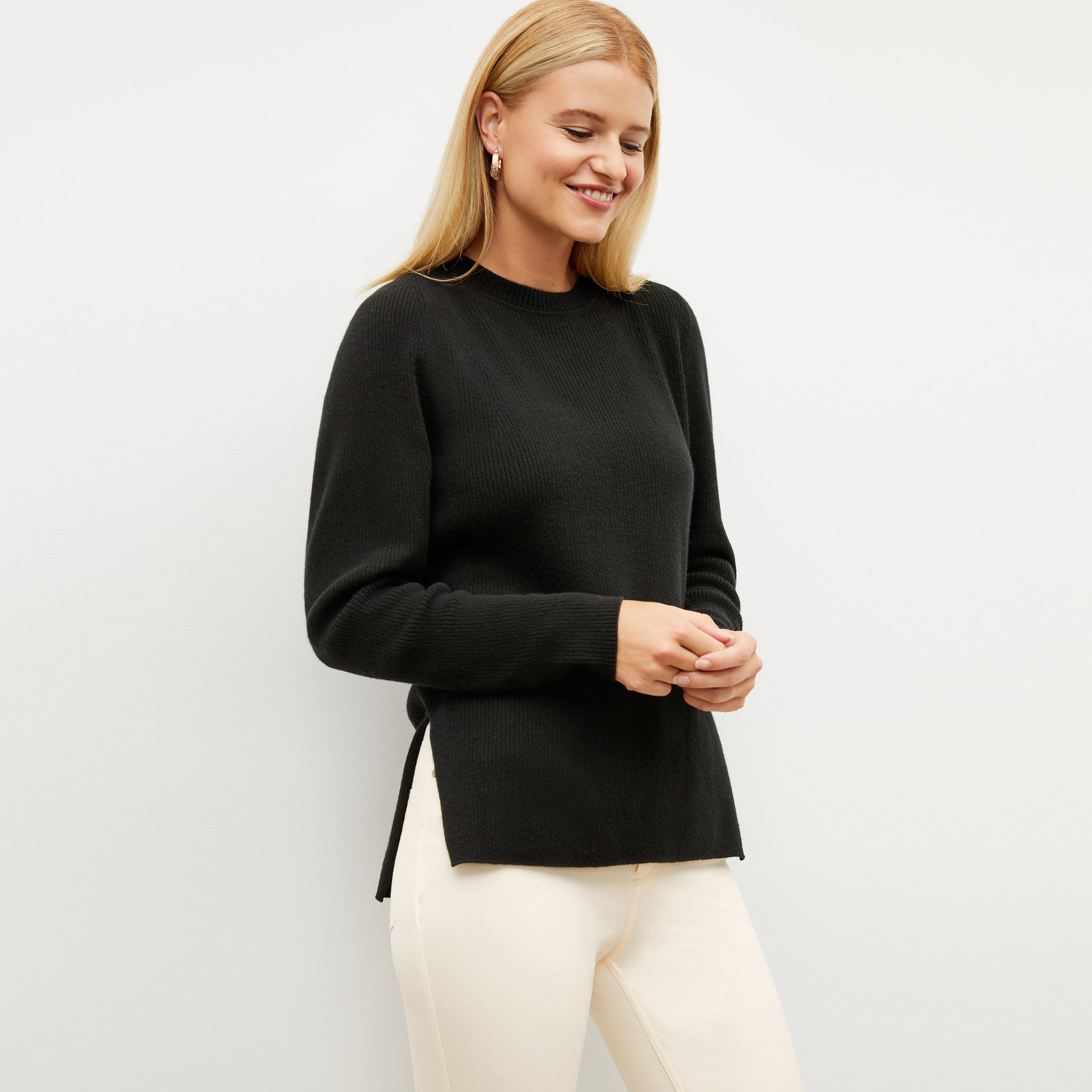 Front image of a woman wearing the ollie sweater in black