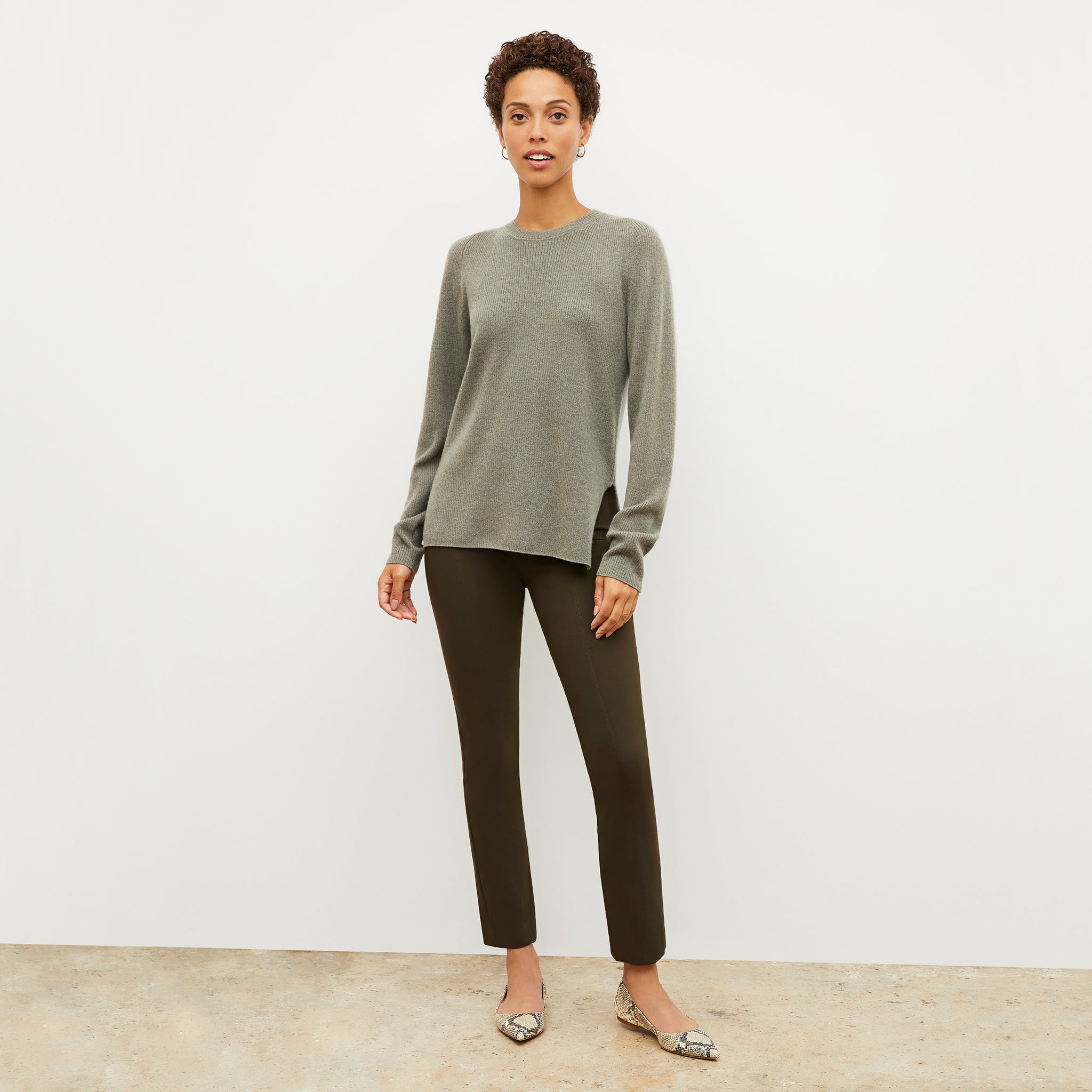 Front image of a woman wearing the ollie sweater in dark moss 