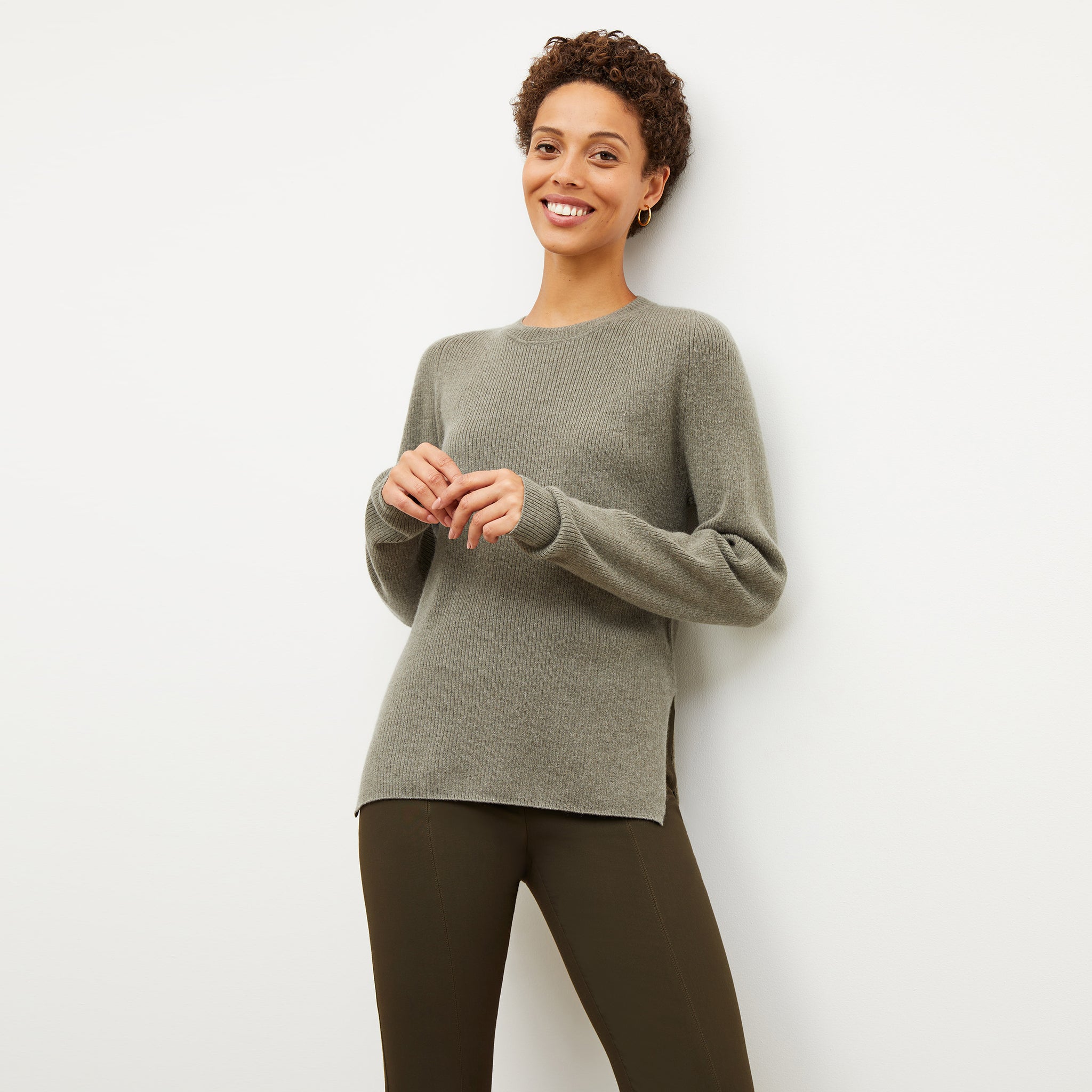 Front image of a woman wearing the ollie sweater in dark moss