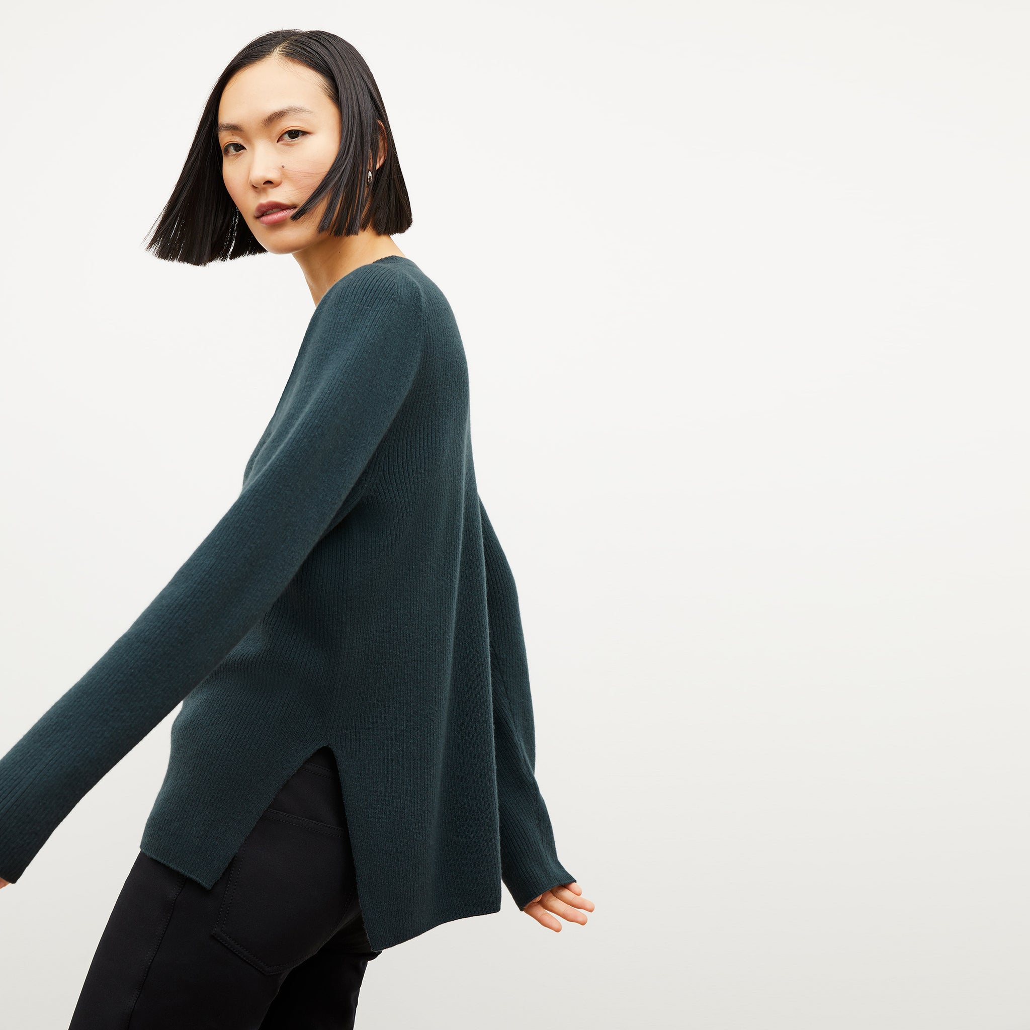 Front image of a woman wearing the ollie sweater in malachite