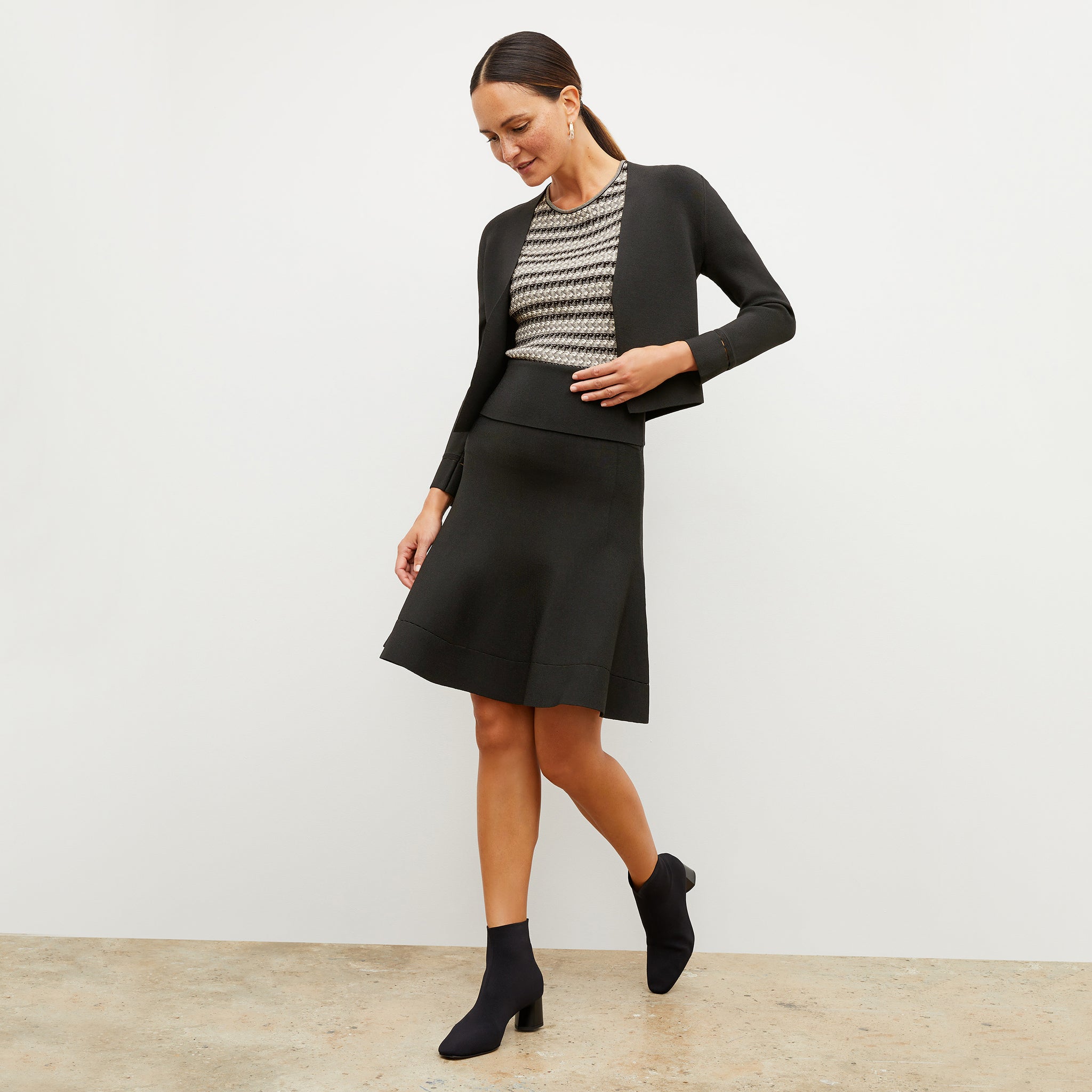 Front image of a woman wearing the luca skirt in black