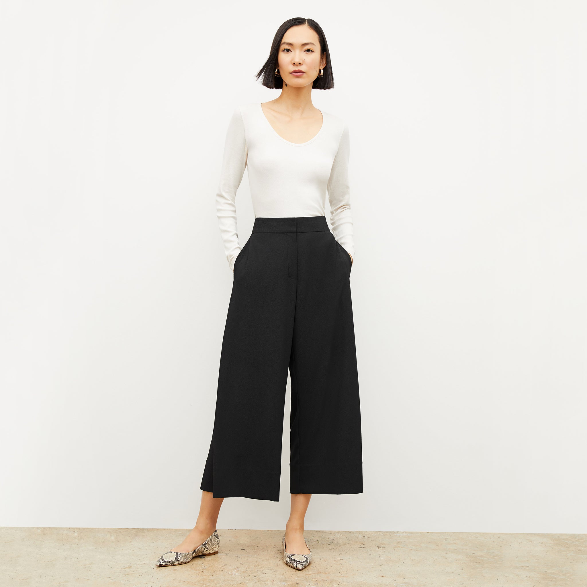 Front image of a woman standing wearing the marcia top in fine ribbed cotton in ivory