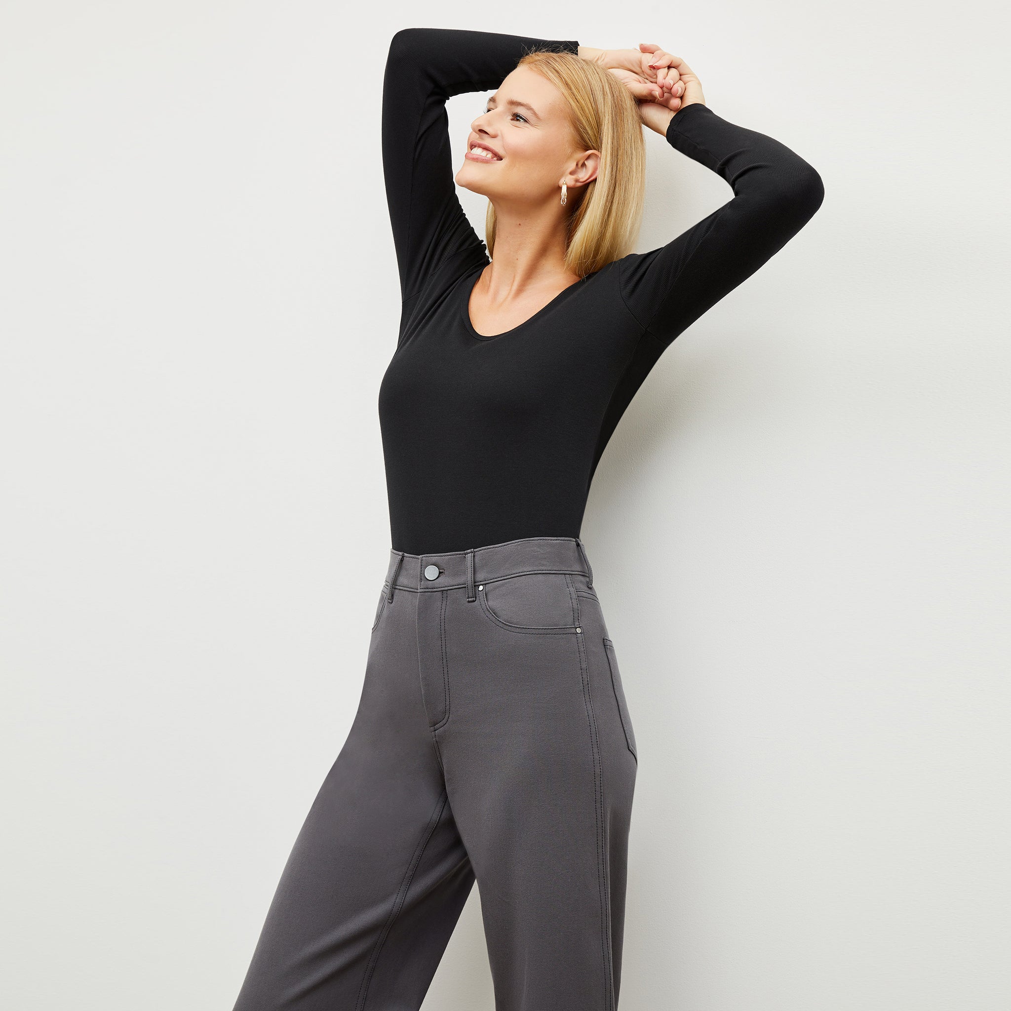 Front image of a woman standing wearing the marcia top in fine ribbed cotton in black