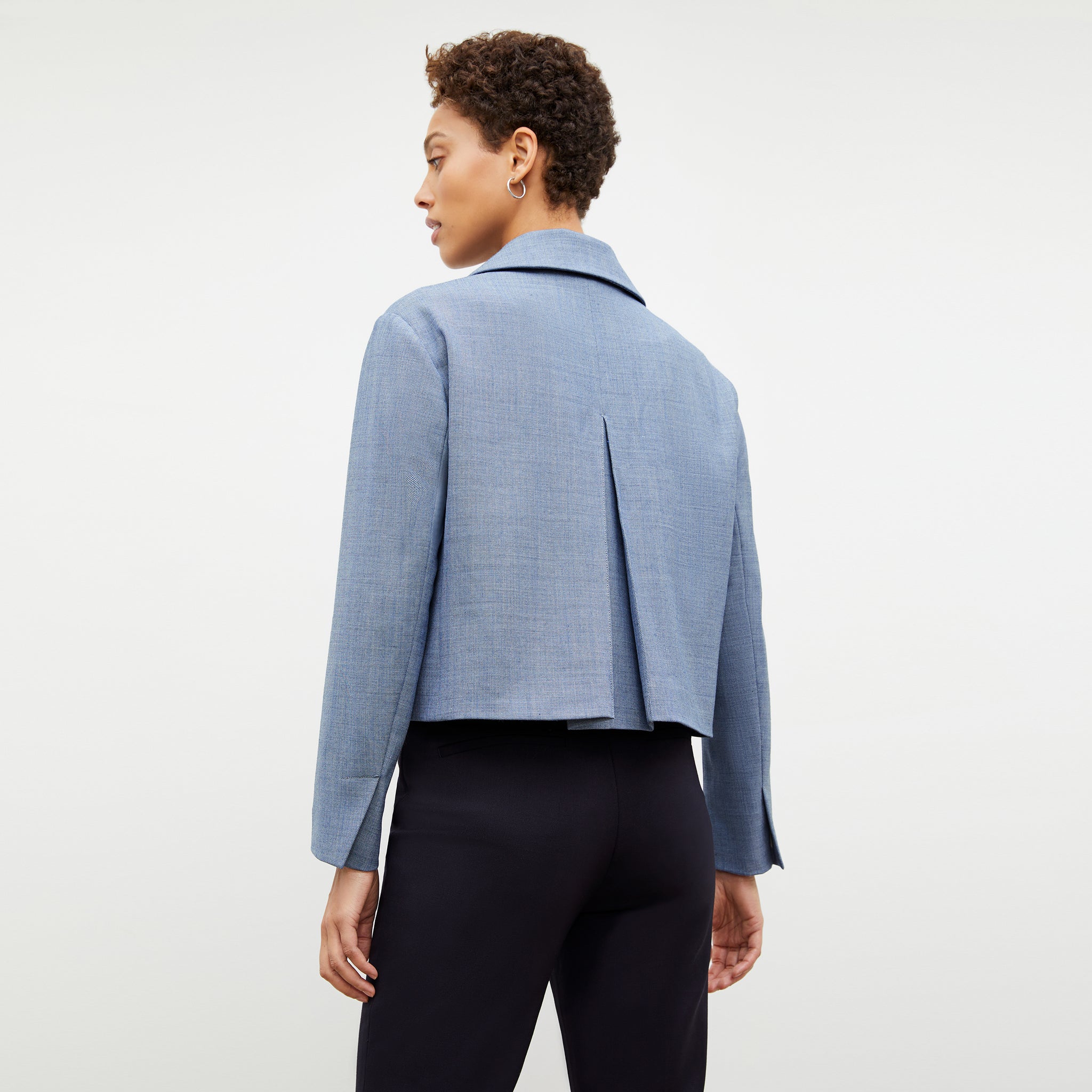 Back image of a woman wearing the nicky jacket in indigo and white