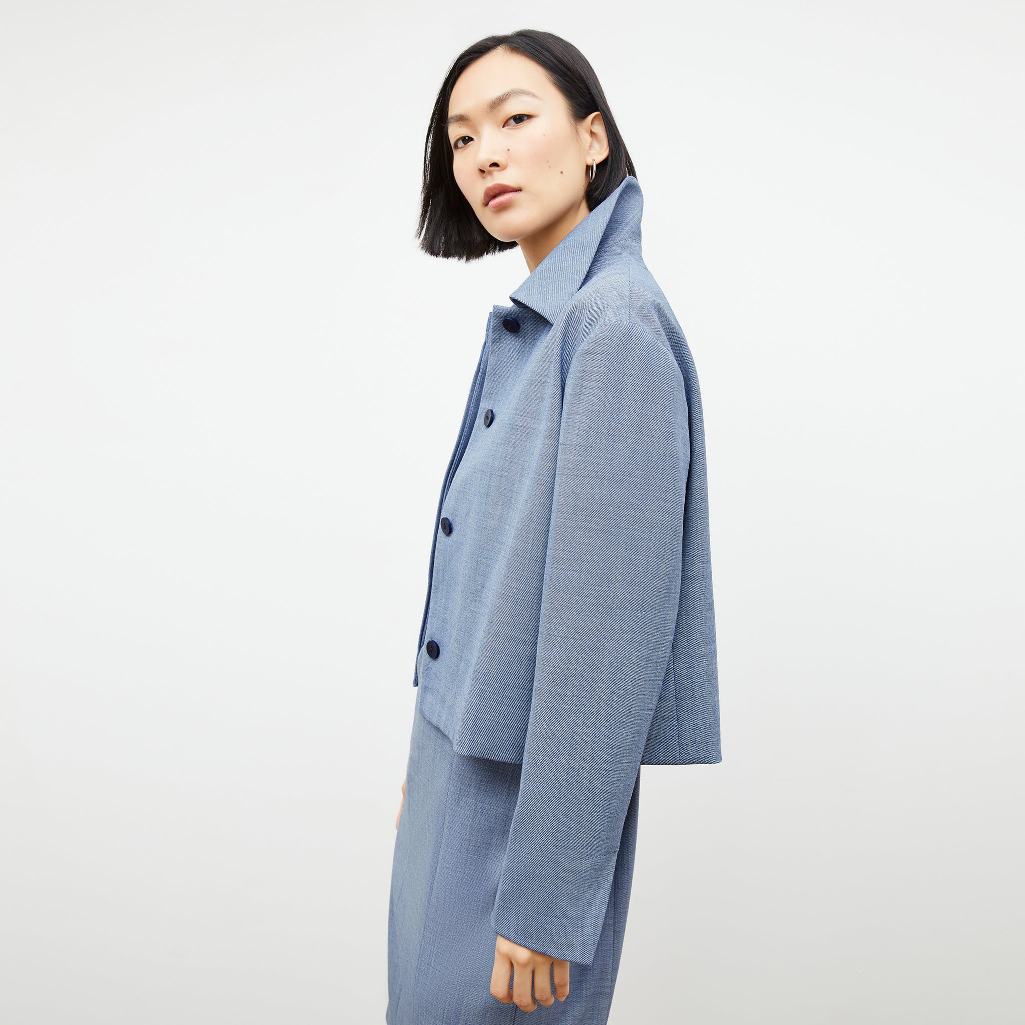 Side image of a woman wearing the nicky jacket in indigo and white