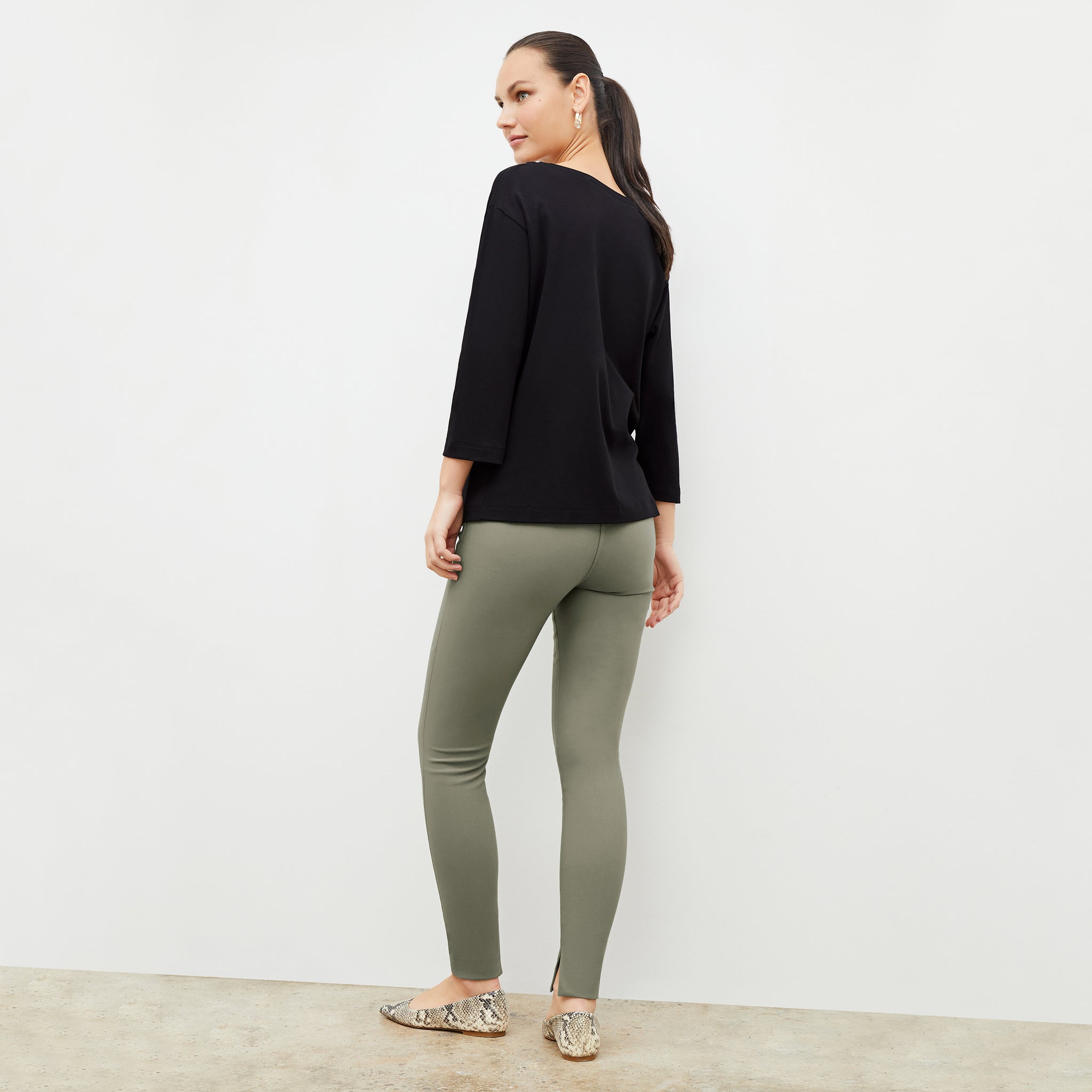 Back image of a woman wearing the skinny foster in thyme