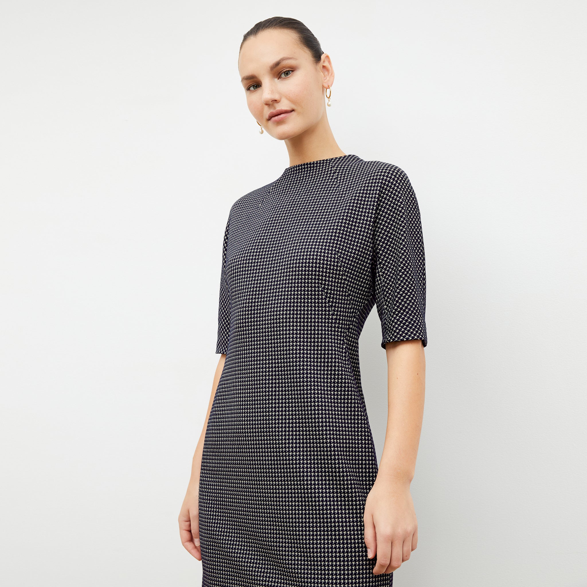 Front image of a woman wearing the farnoosh dress in black and white houndstooth 